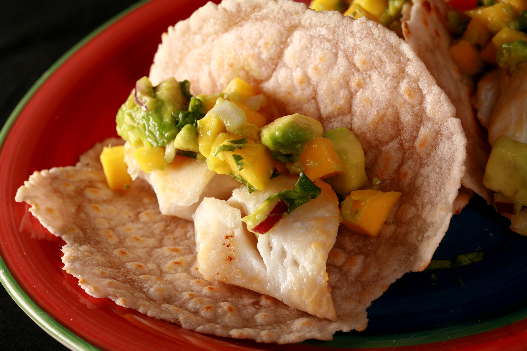 Cassava flour paleo fish tacos, with mango salsa, on a red plate.