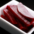 A small white bowl with slices of Paleo Quick Beet Pickles in it.
