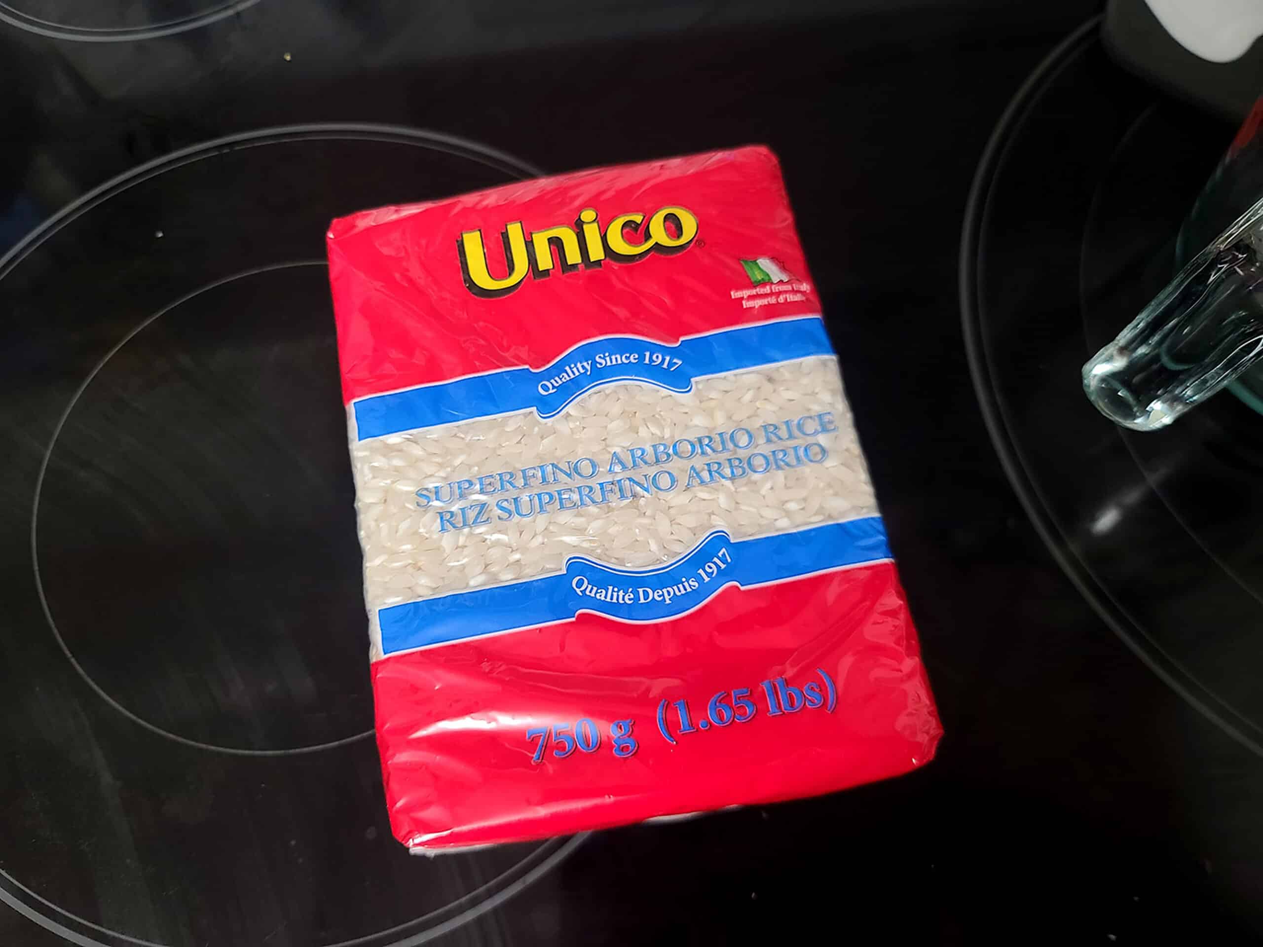 A brick of arborio rice sitting on a stove top.