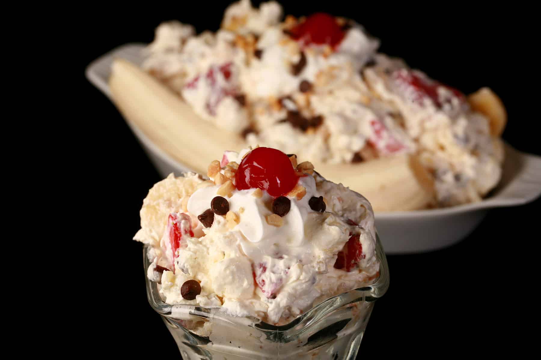 Banana Split Fluff Salad in a glass bowl, in front of a serving done up like an actual banana split.