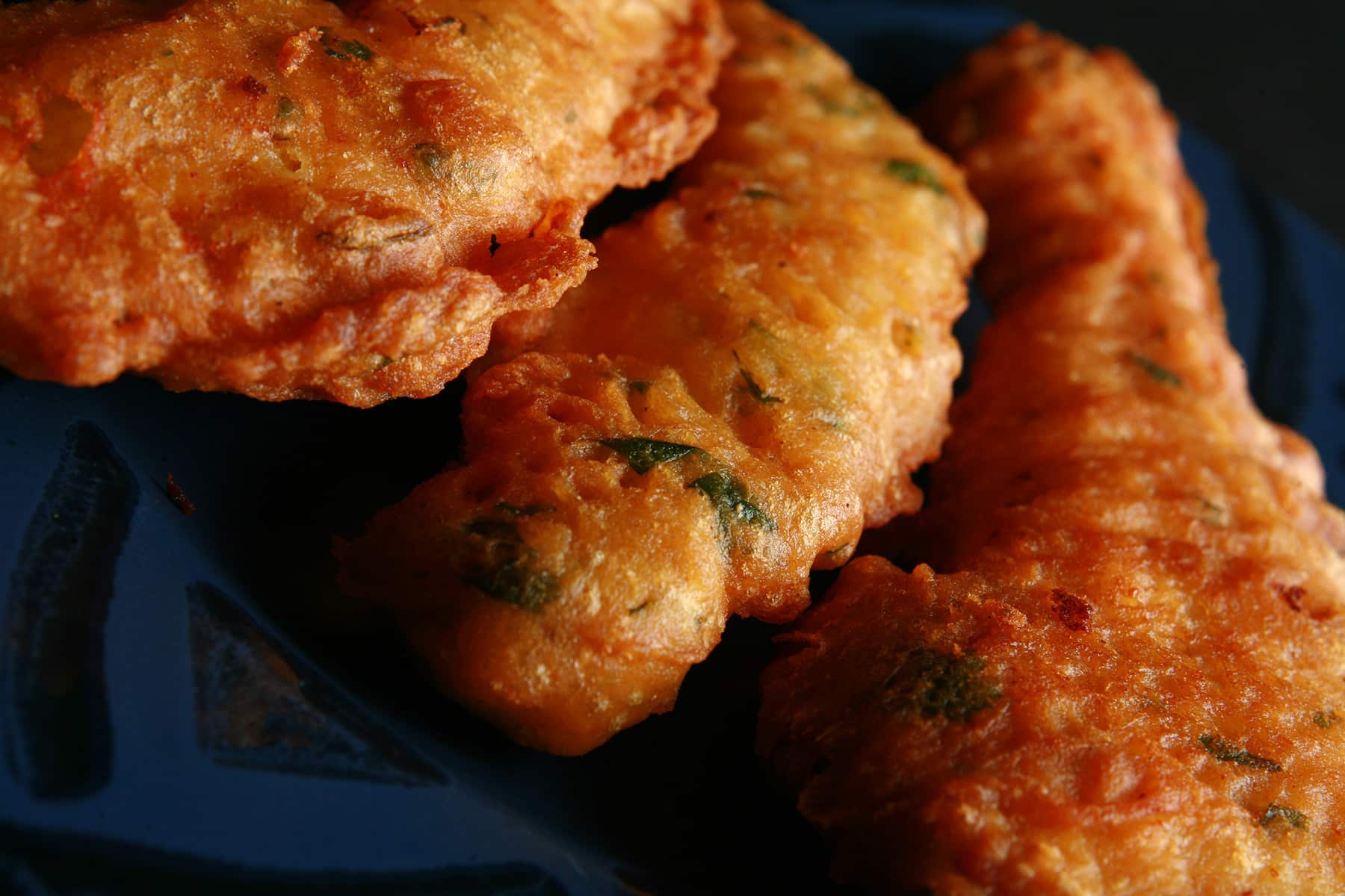 Several chicken pakoras on a blue plate.