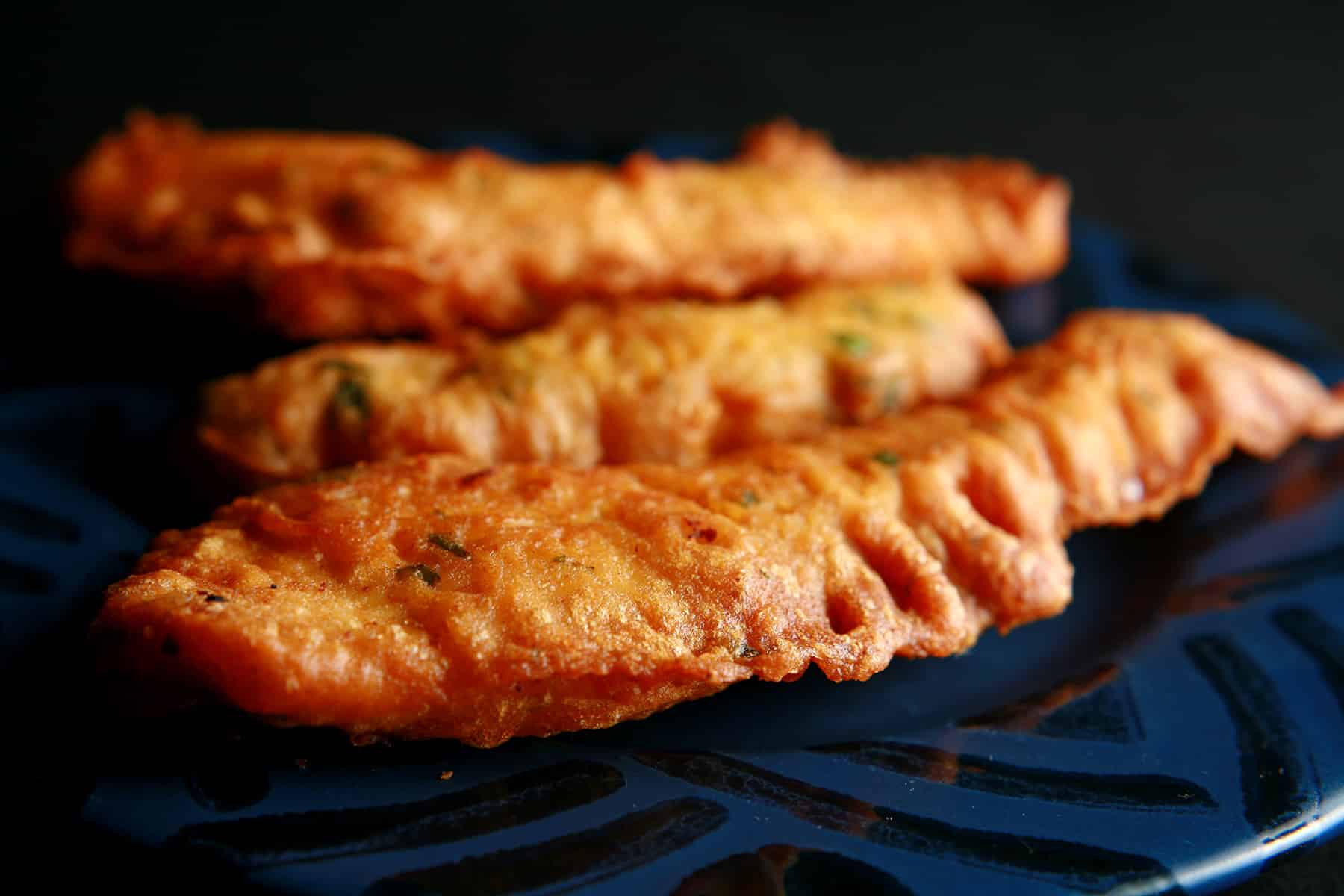 Several chicken pakoras on a blue plate.