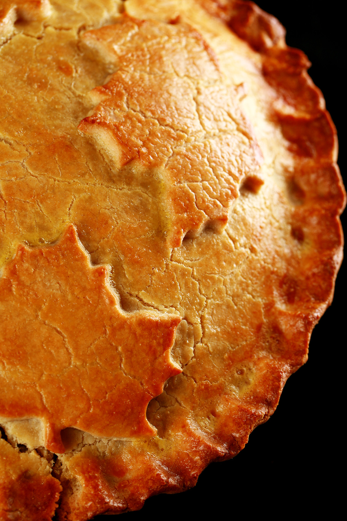 A close up photo of a cut-open chicken mushroom tourtiere pie. The crust has maple leaves on it.