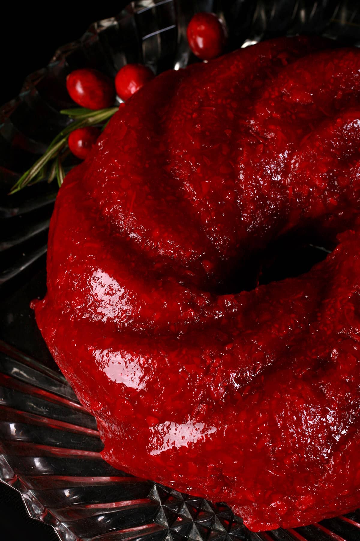 A molded cranberry Jello salad on a glass plate.
