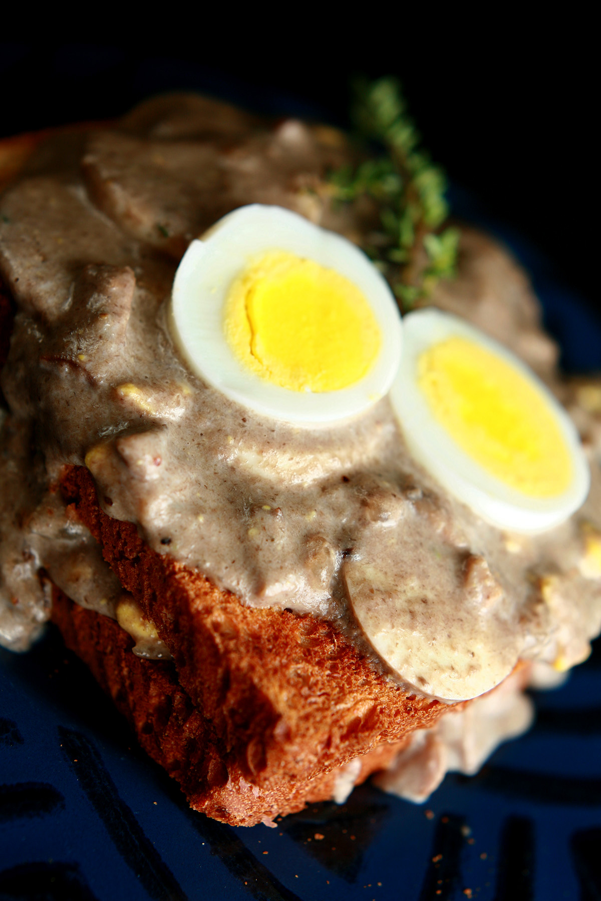 Gluten-Free Mushroom Soup and Eggs on Toast, garnished with hardboiled egg slices and thyme.