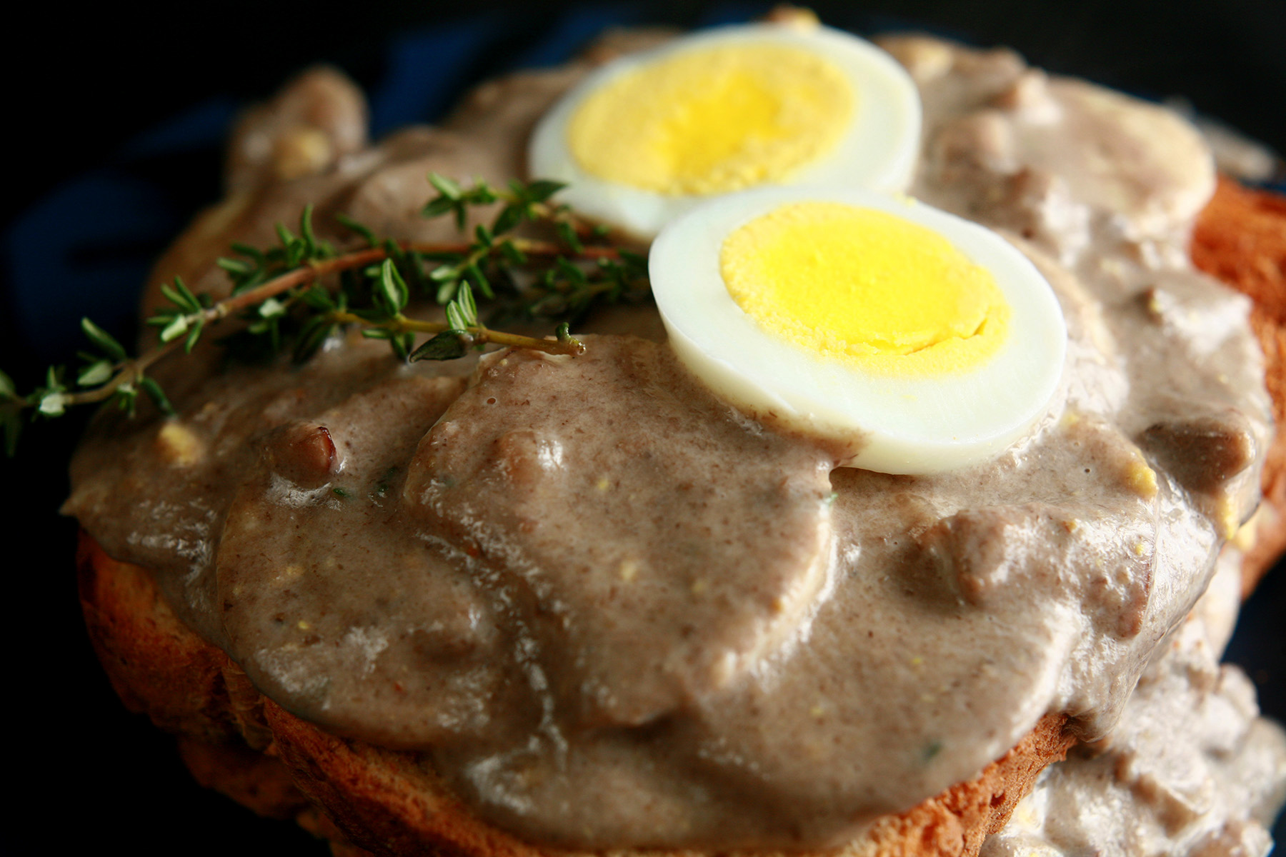 Gluten-Free Mushroom Soup and Eggs on Toast, garnished with hardboiled egg slices and thyme.