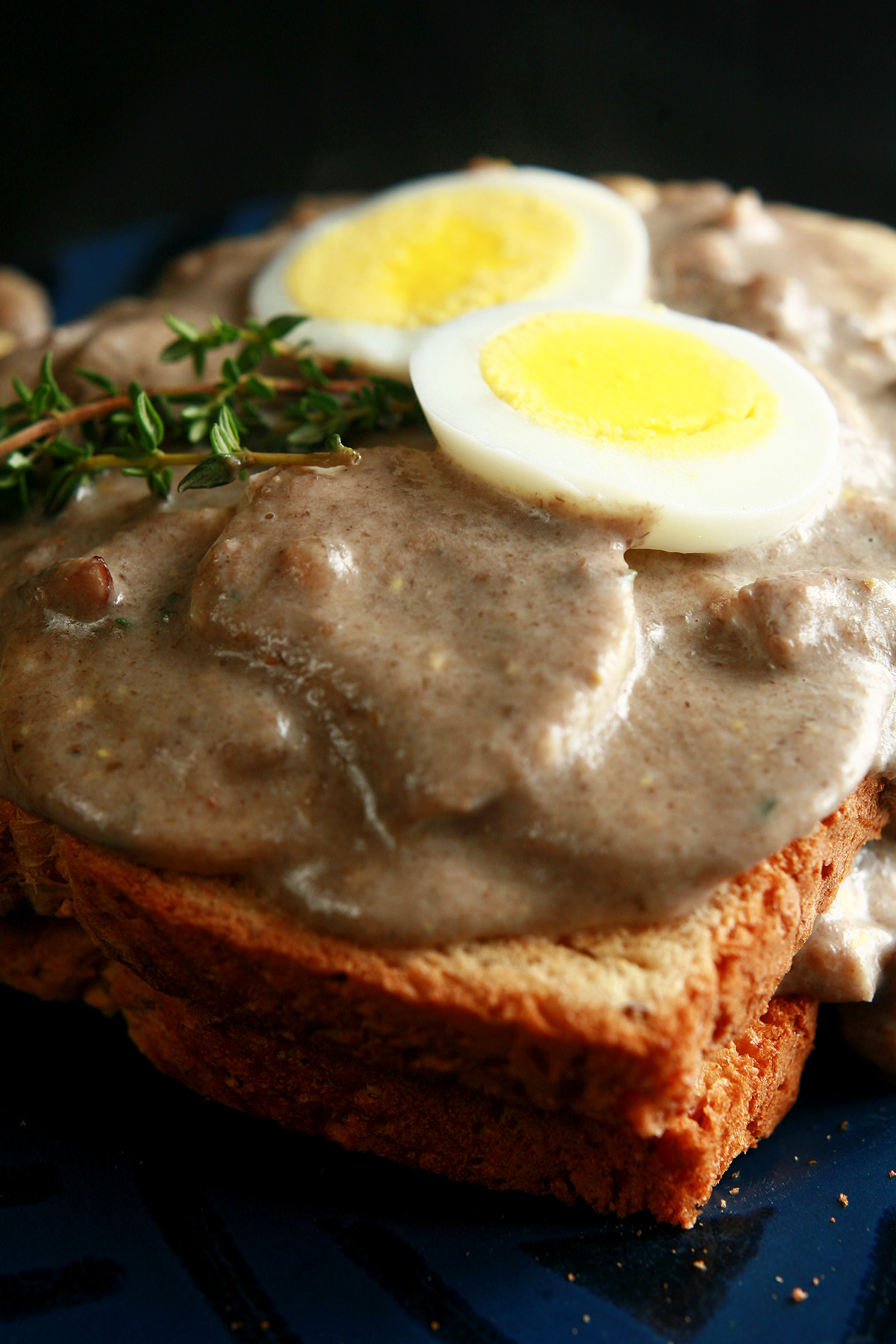 Gluten-Free Mushroom Soup and Eggs on Toast, garnished with hardboiled egg slices and thyme.