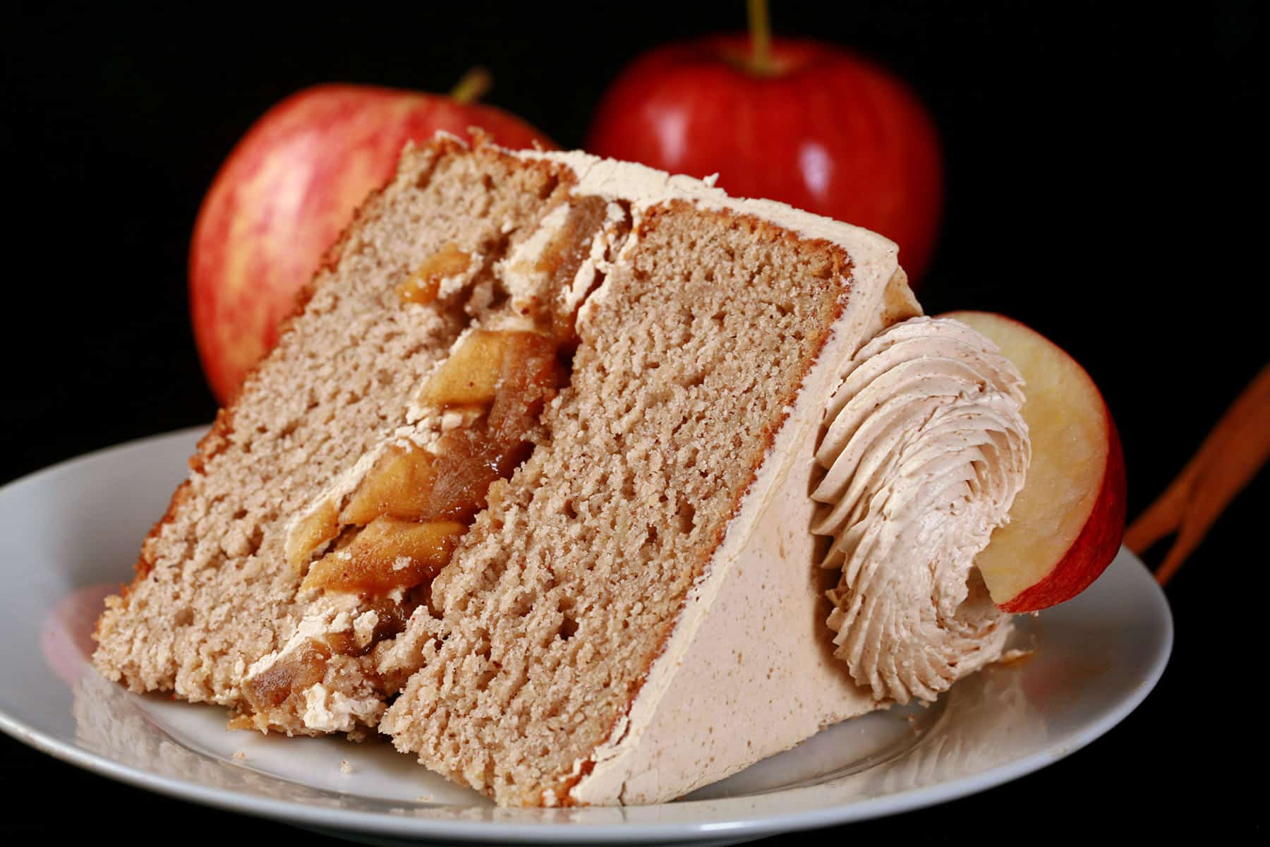 A slice of gluten-free apple cake, with apples in the background.