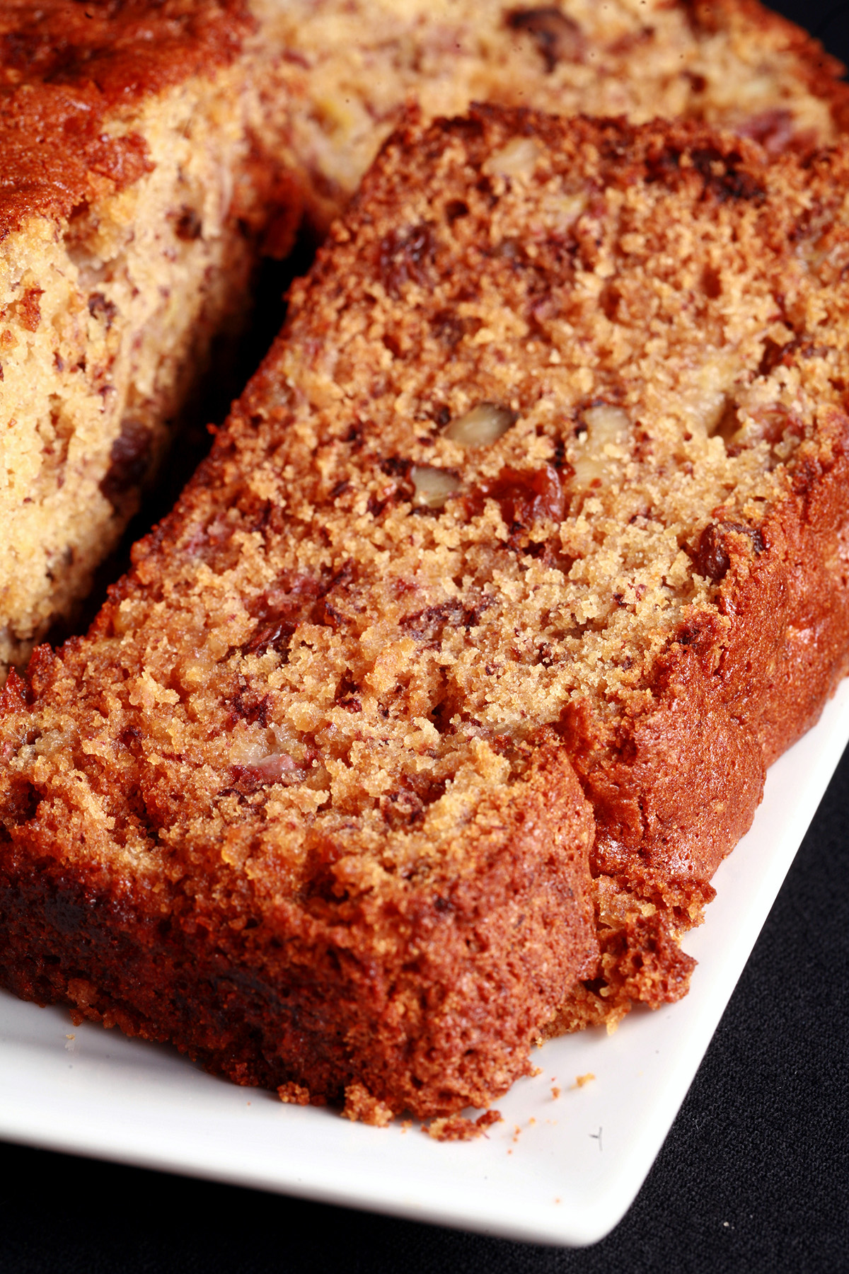A loaf of easy gluten free banana bread with a slice cut from it.