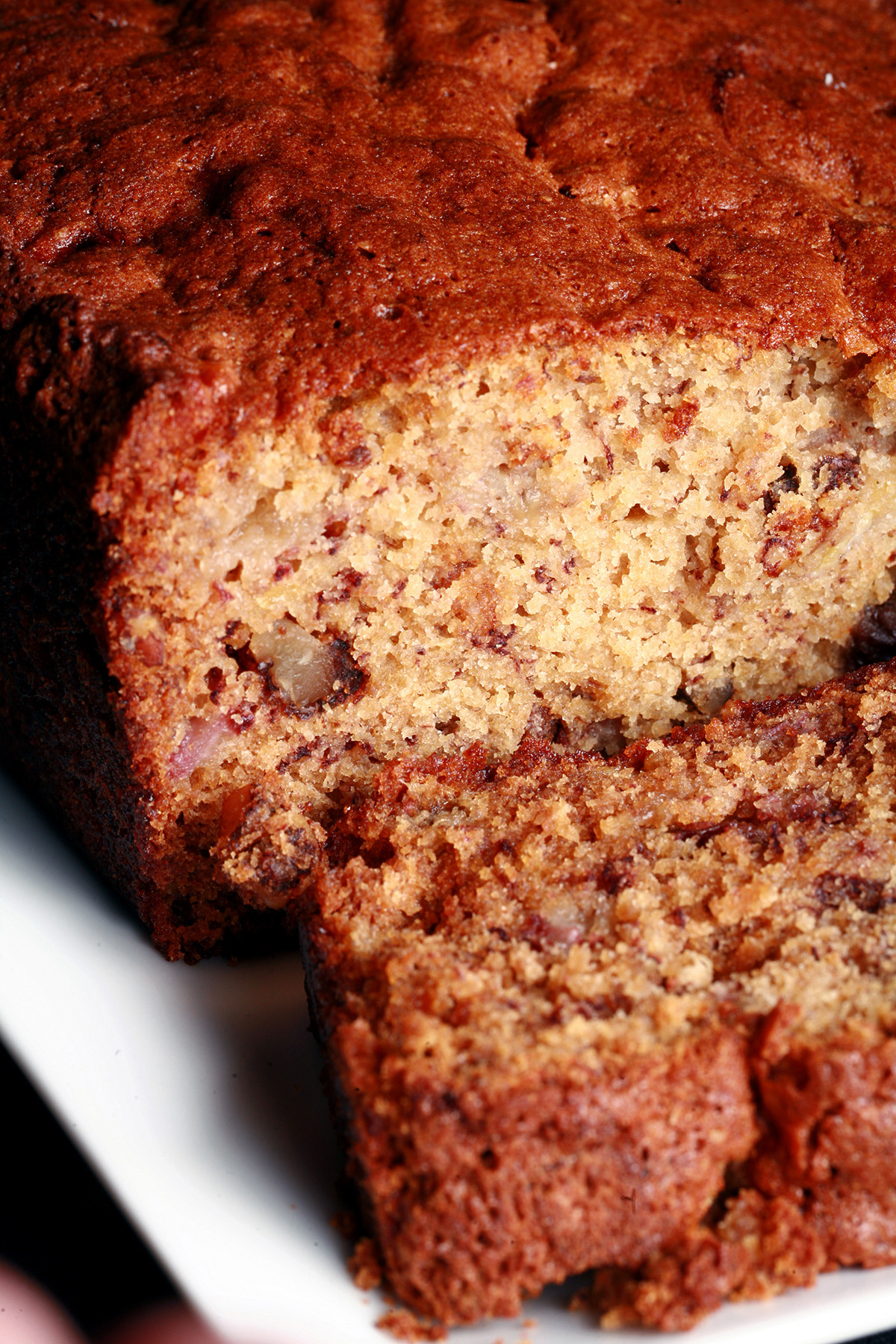 A loaf of easy gluten free banana bread with a slice cut from it.