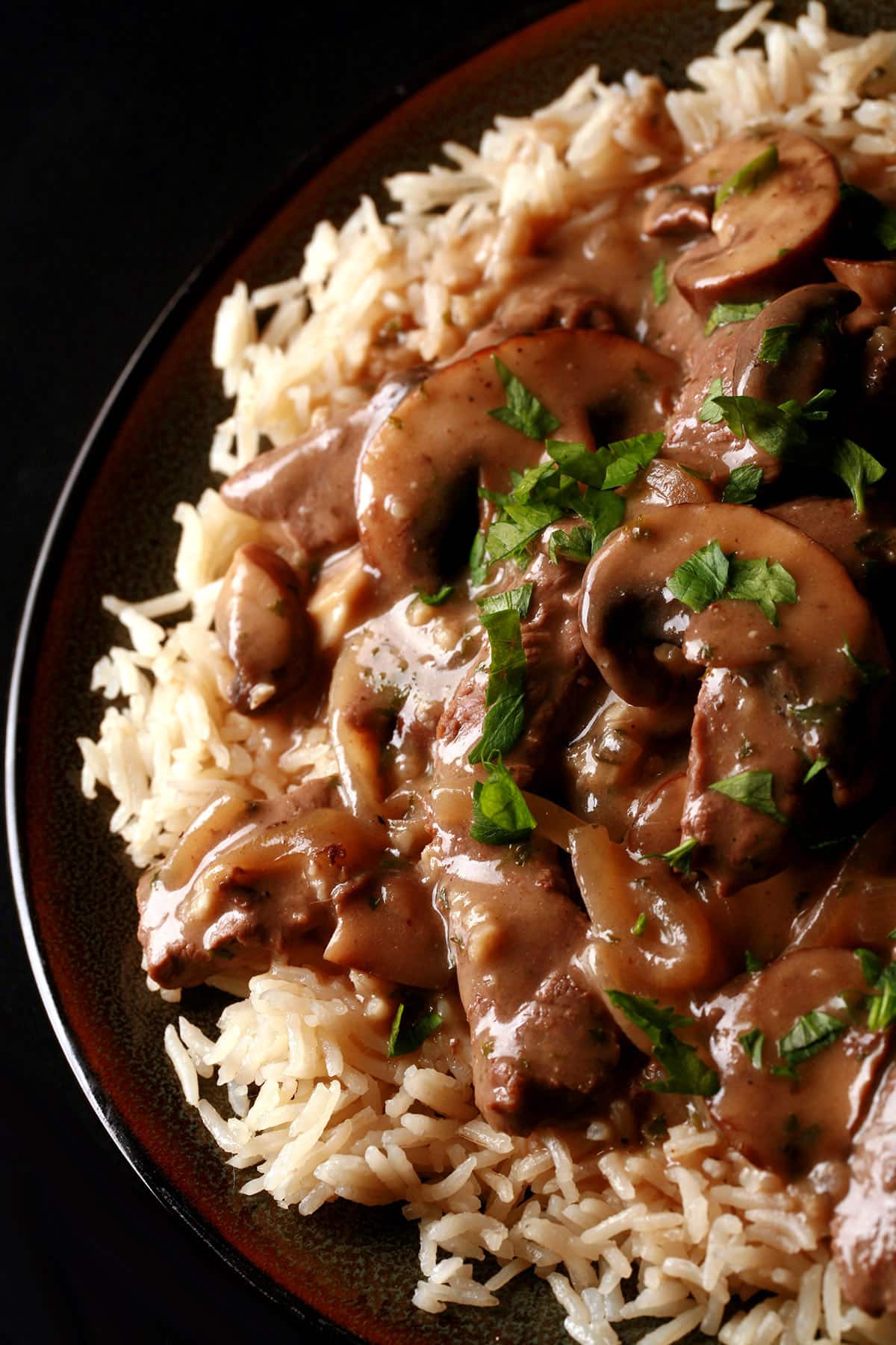 A serving of gluten-free beef stroganoff over a bed of rice.