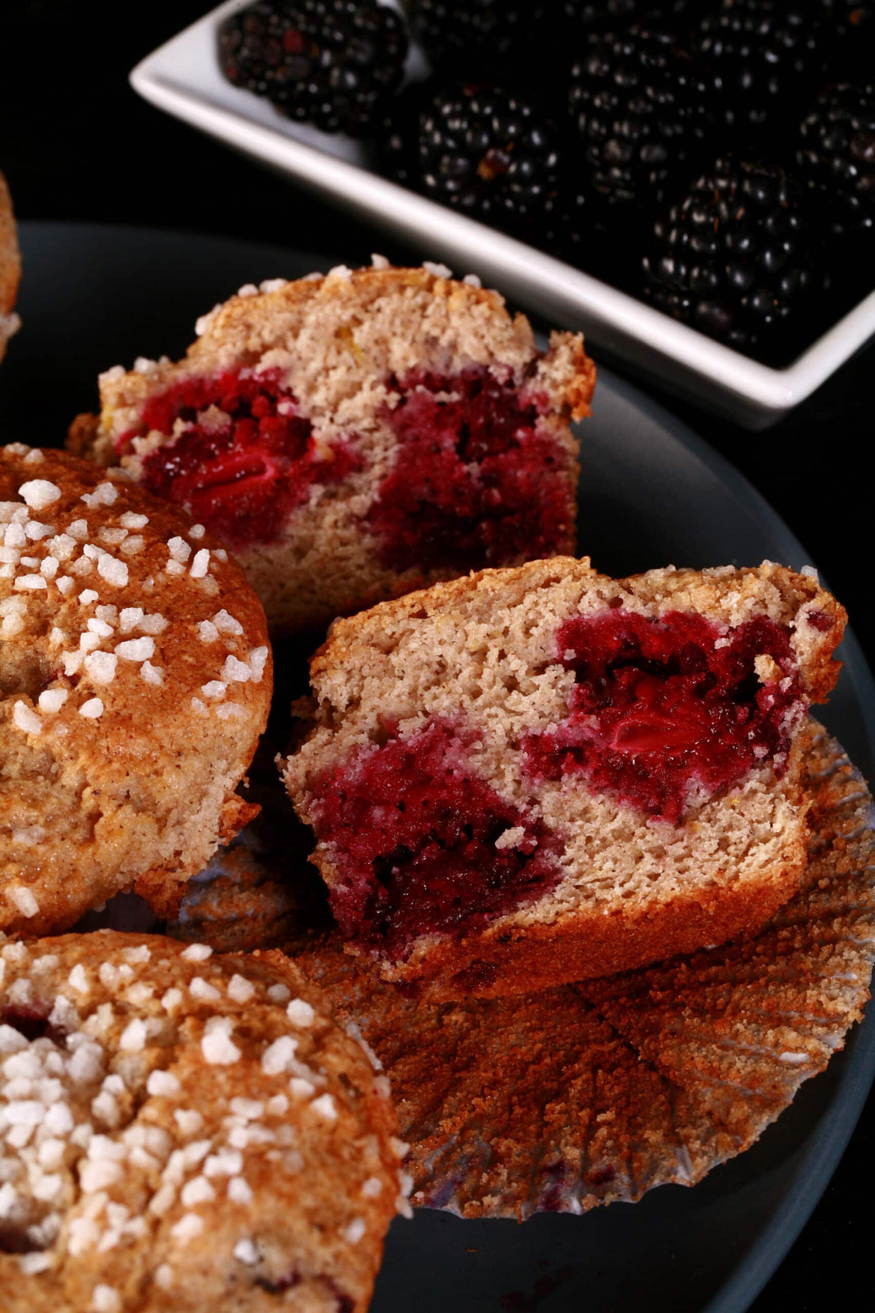 A plate of sugar crusted gluten free blackberry muffins.