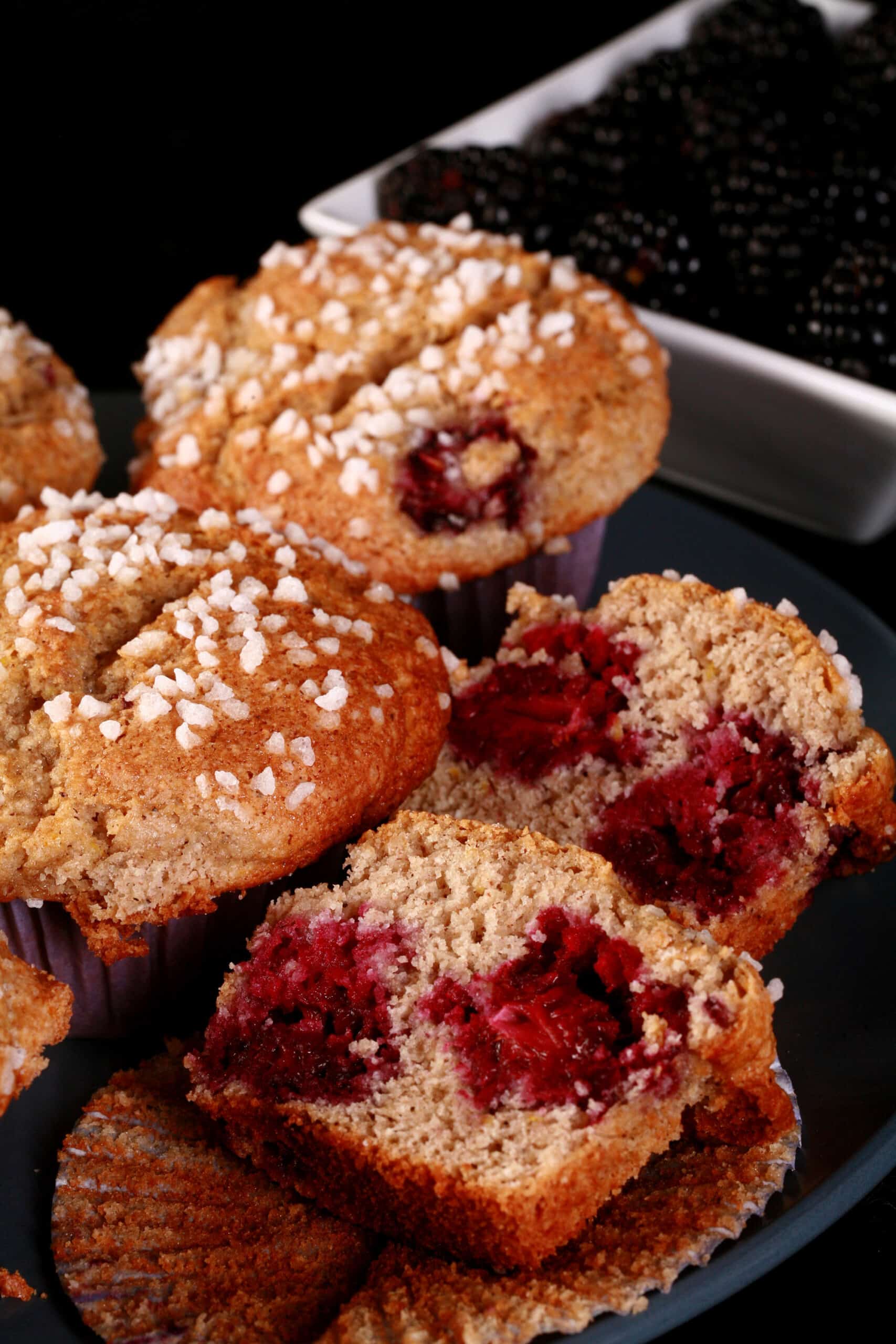 A plate of sugar crusted gluten-free blackberry muffins.