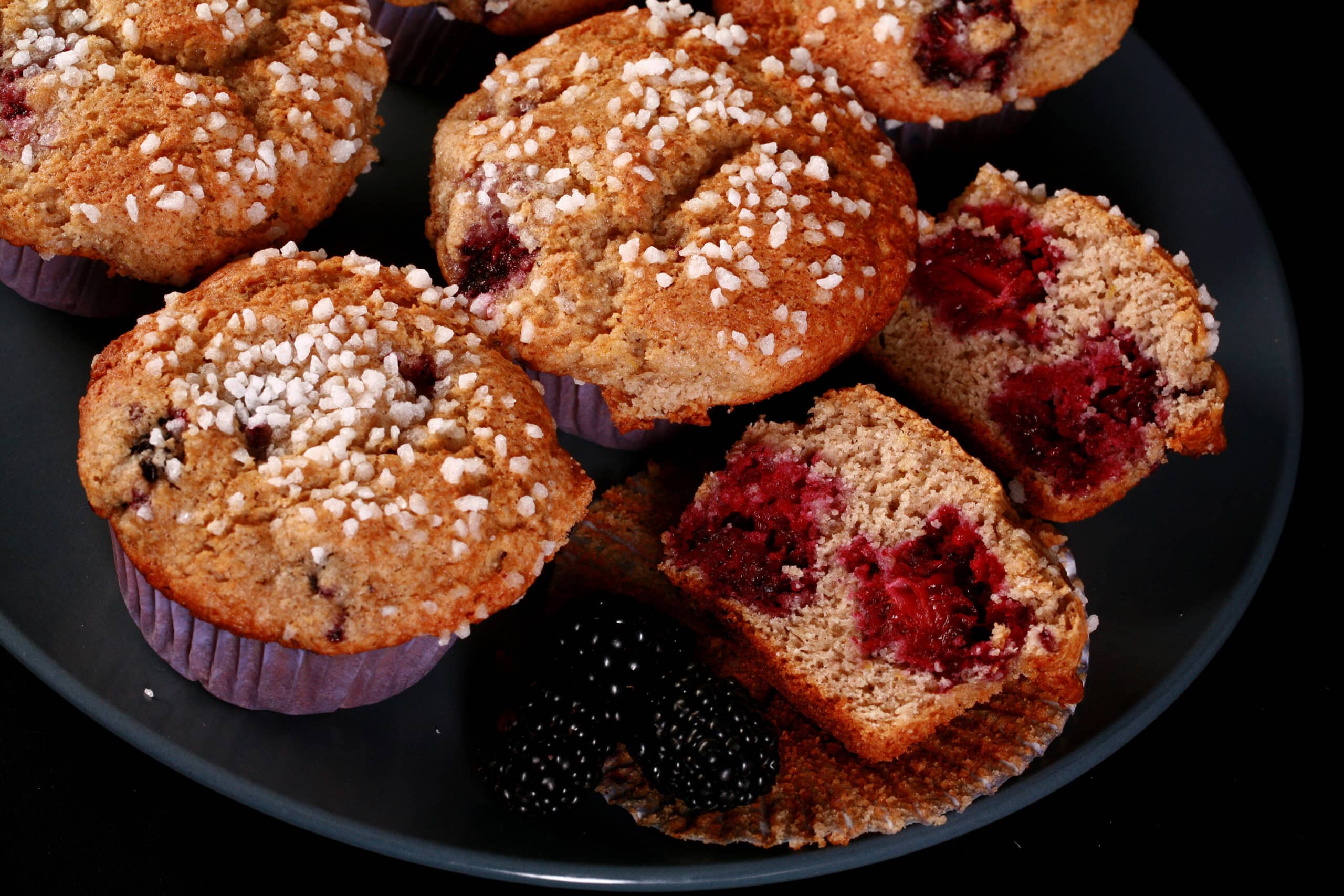 A plate of sugar crusted gluten-free blackberry muffins.