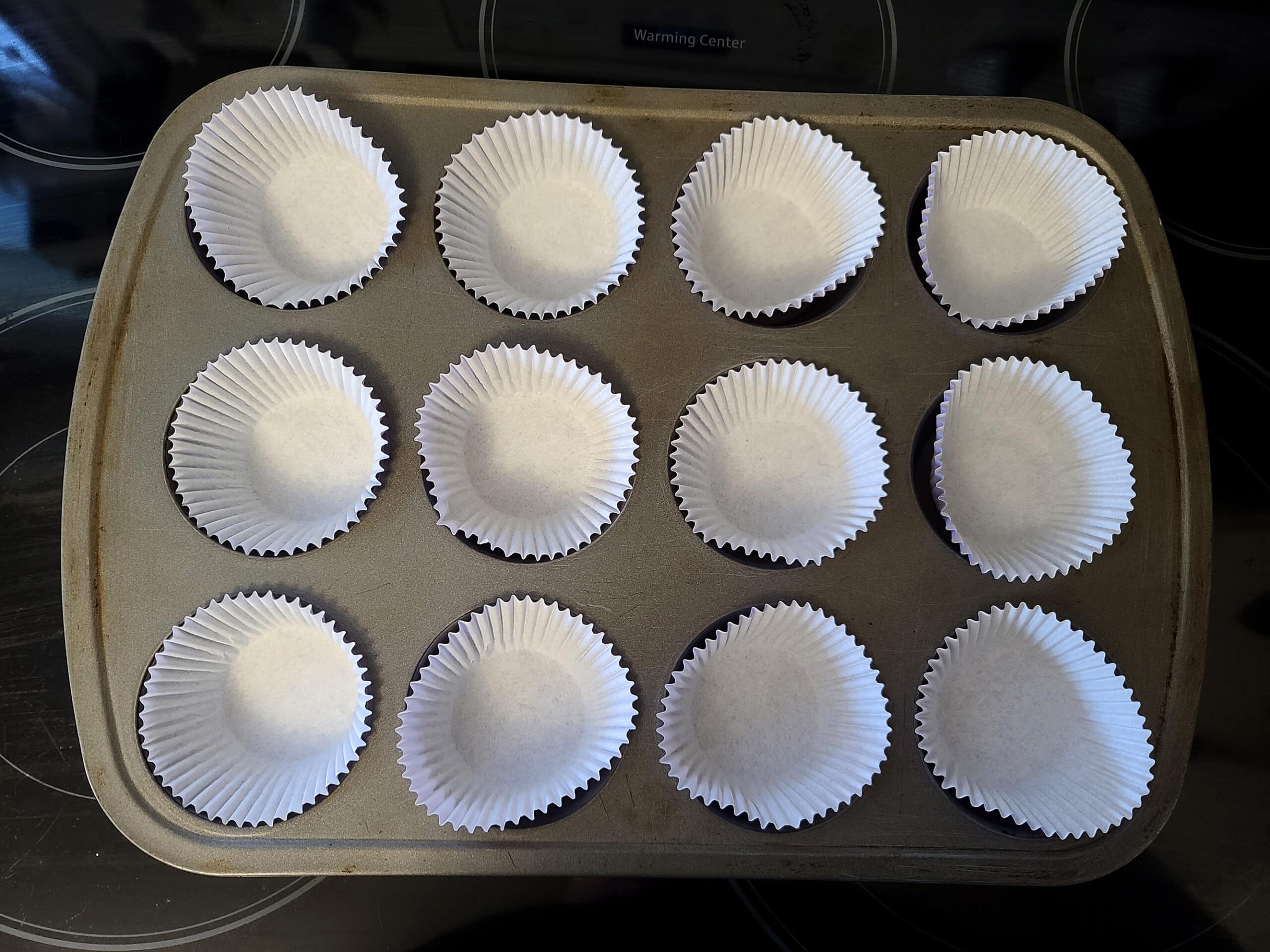 A muffin pan lined with cupcake liners.