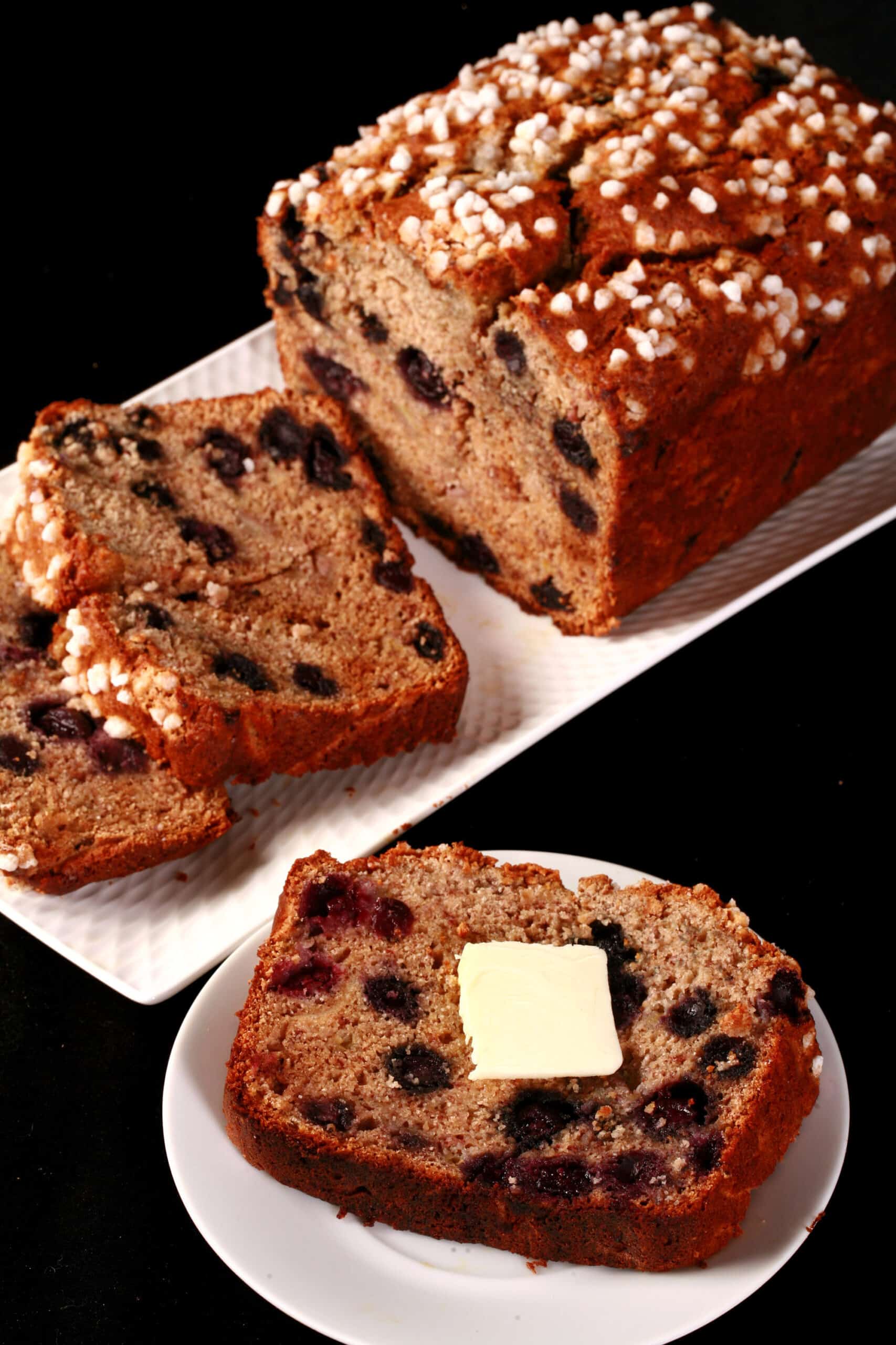 A sliced loaf of gluten free banana blueberry bread.