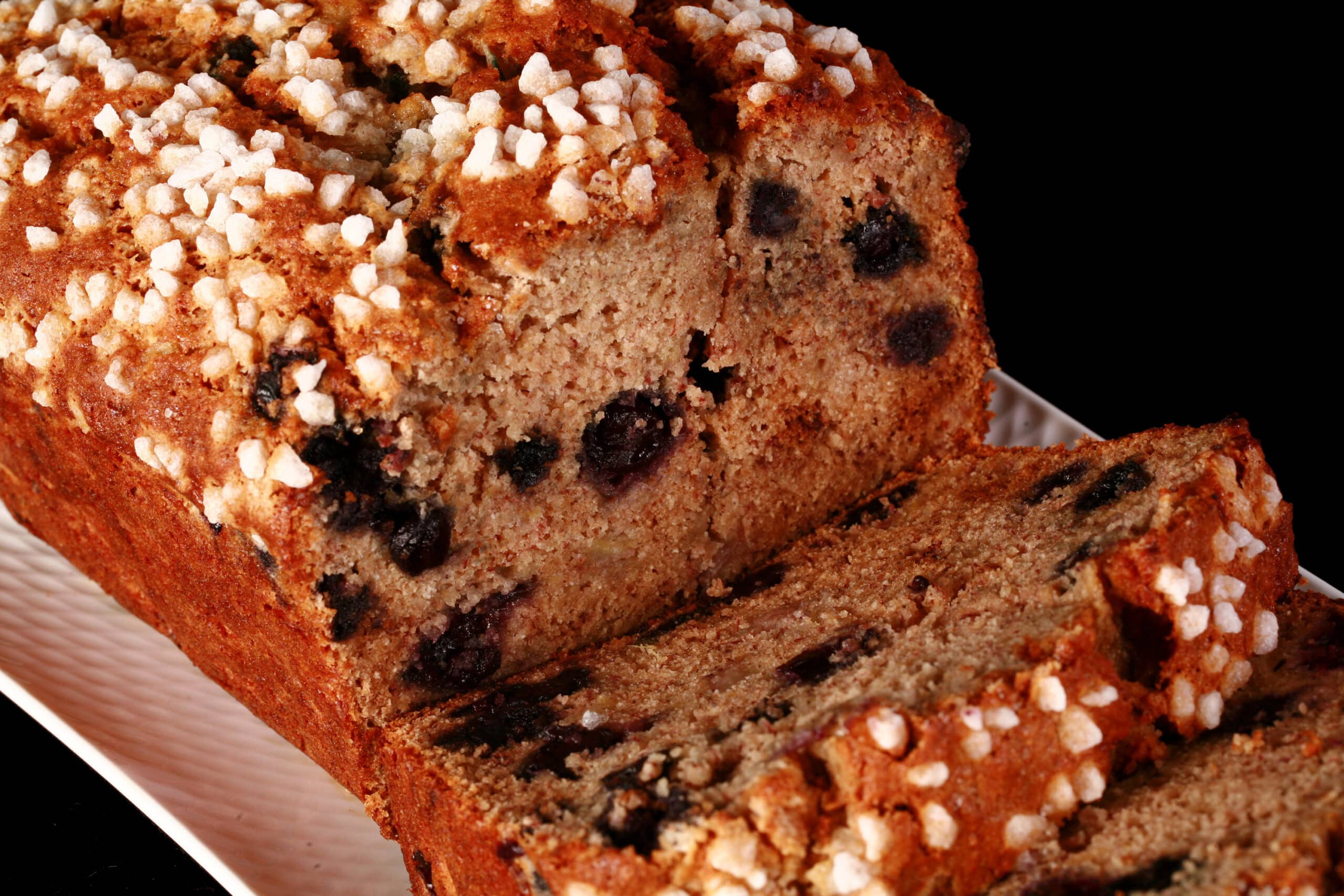A sliced loaf of gluten-free blueberry banana bread.