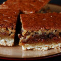Close up view of a plate of gluten free butter tart squares.