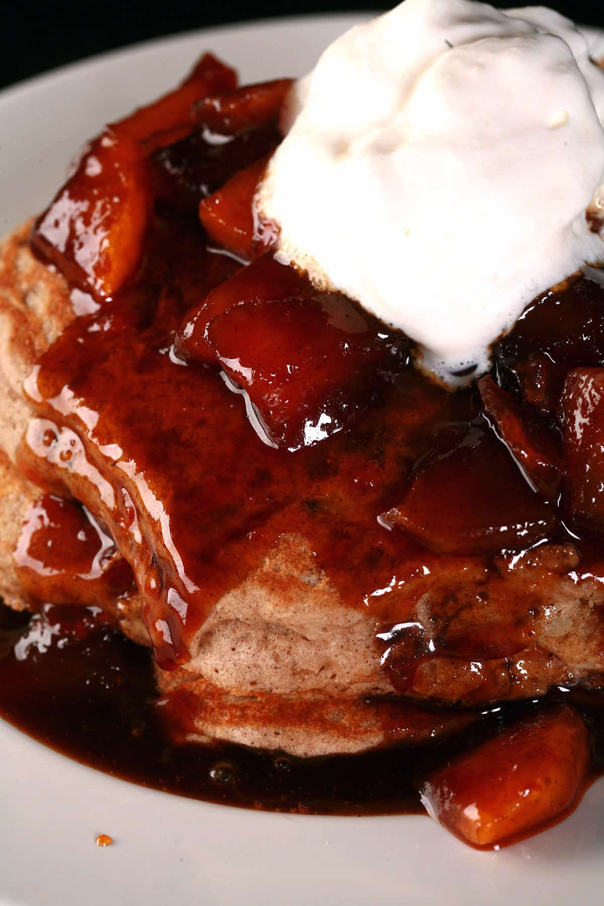 A stack of gluten free apple pancakes with caramel apple topping.
