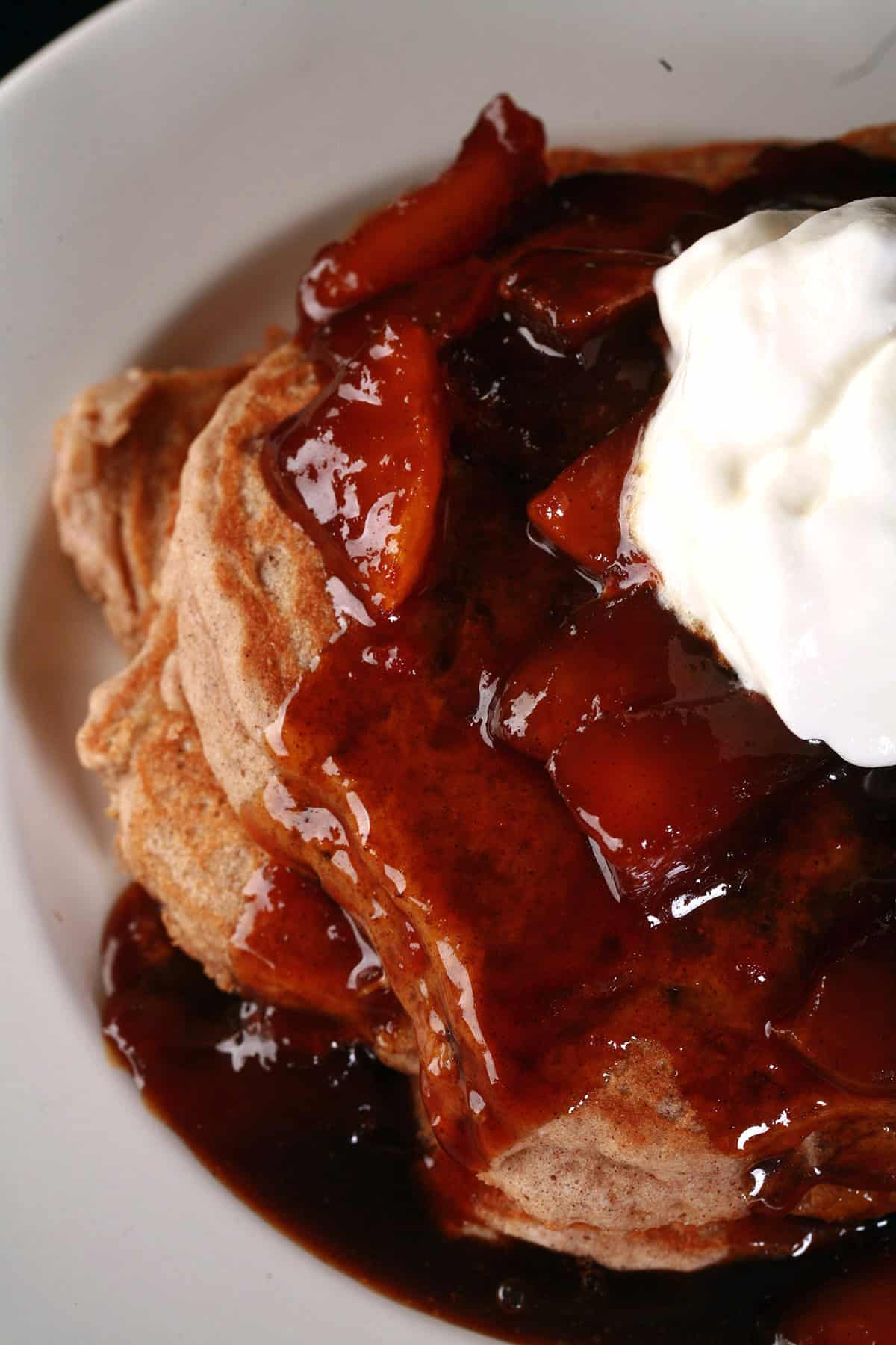 A stack of gluten free apple pancakes with caramel apple topping.