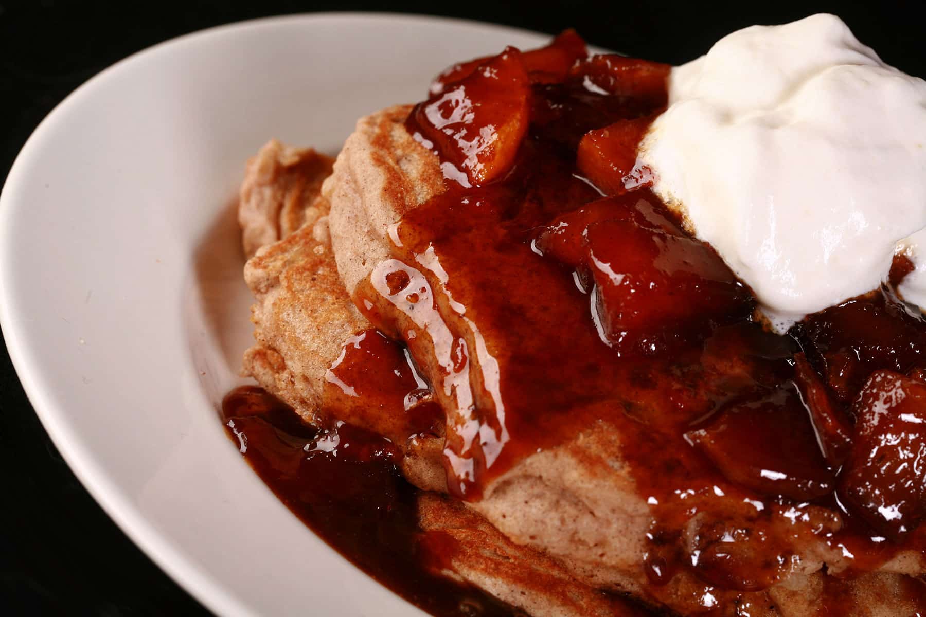 A stack of gluten-free apple pancakes with caramel apple topping.