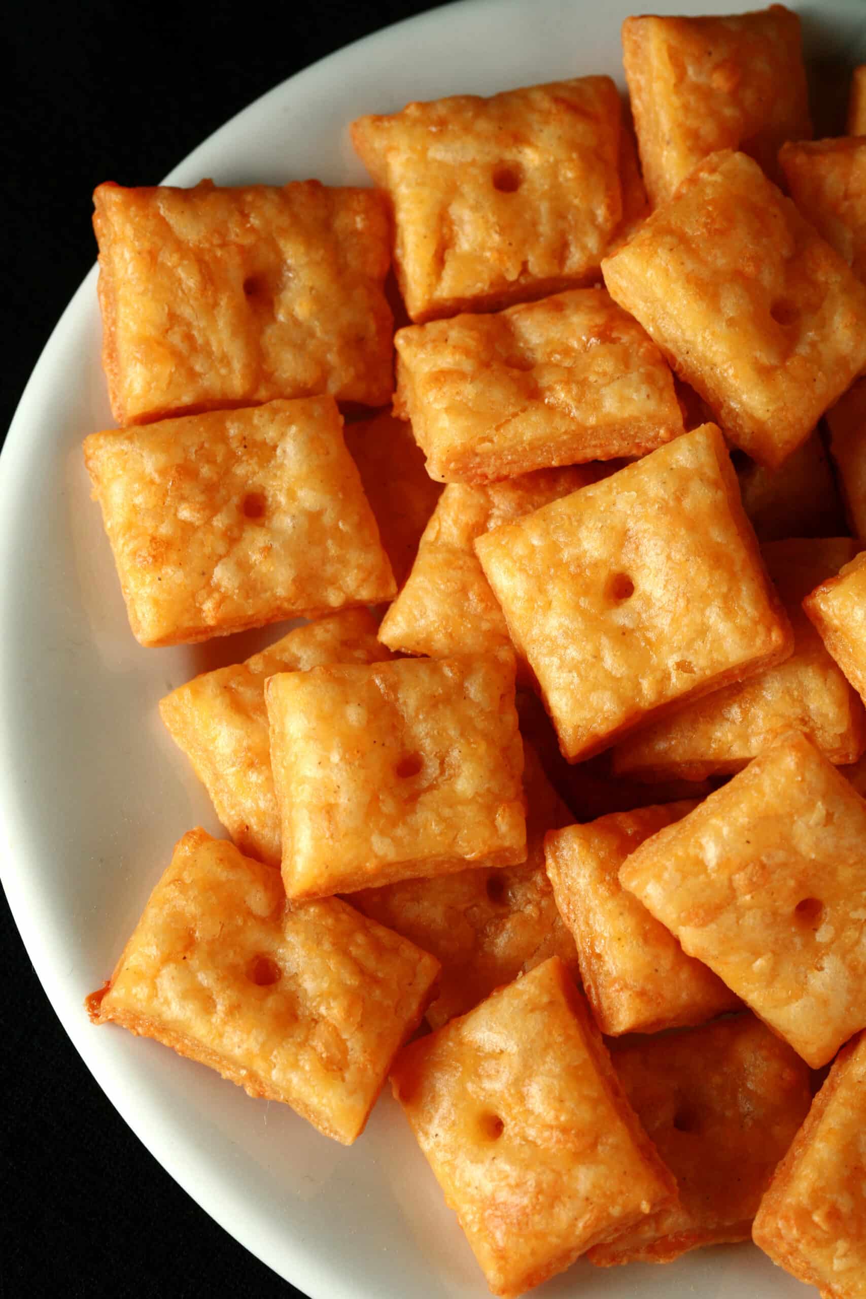 A plate of gluten free cheez its cheese crackers.