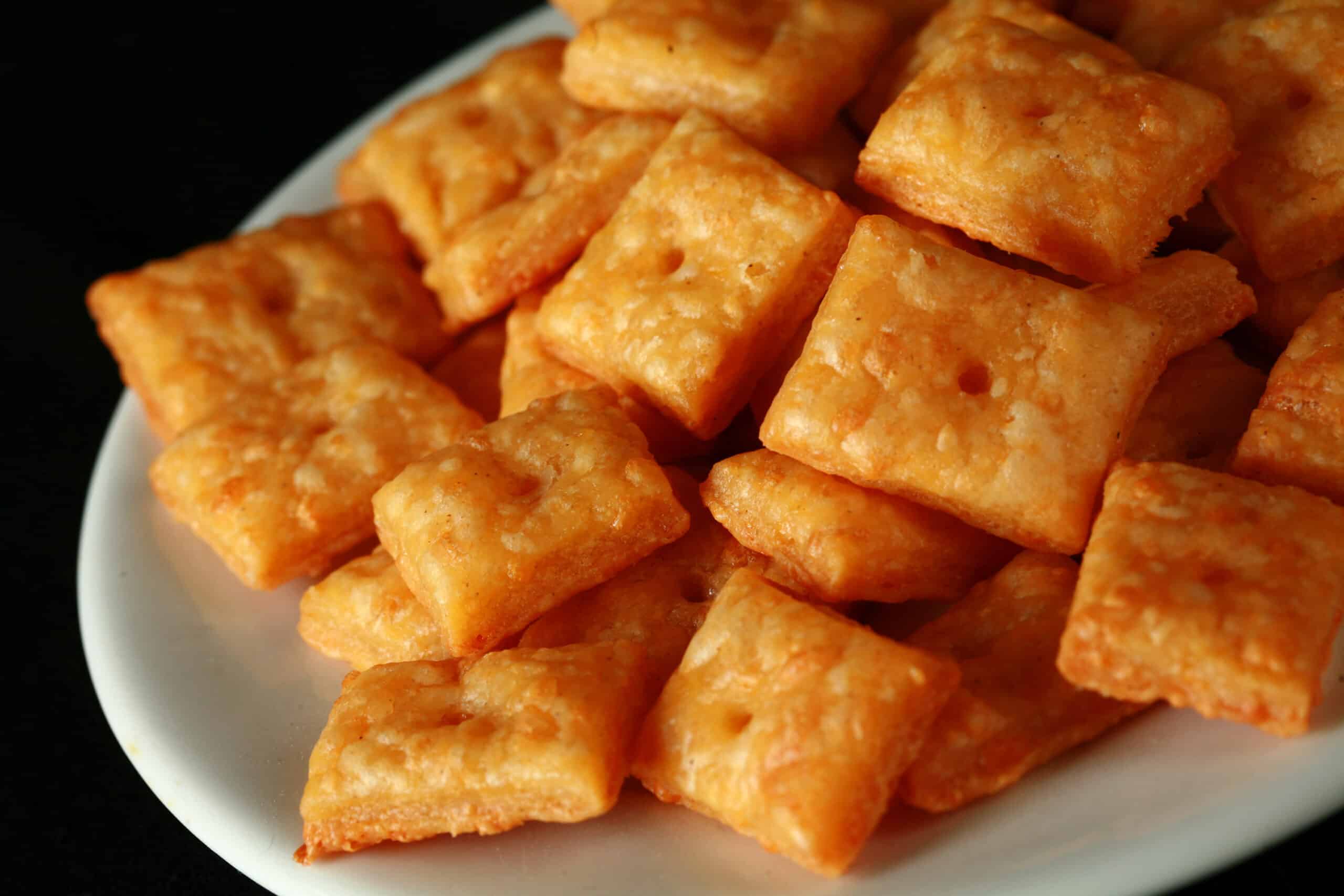 A plate of gluten free cheez its cheese crackers.