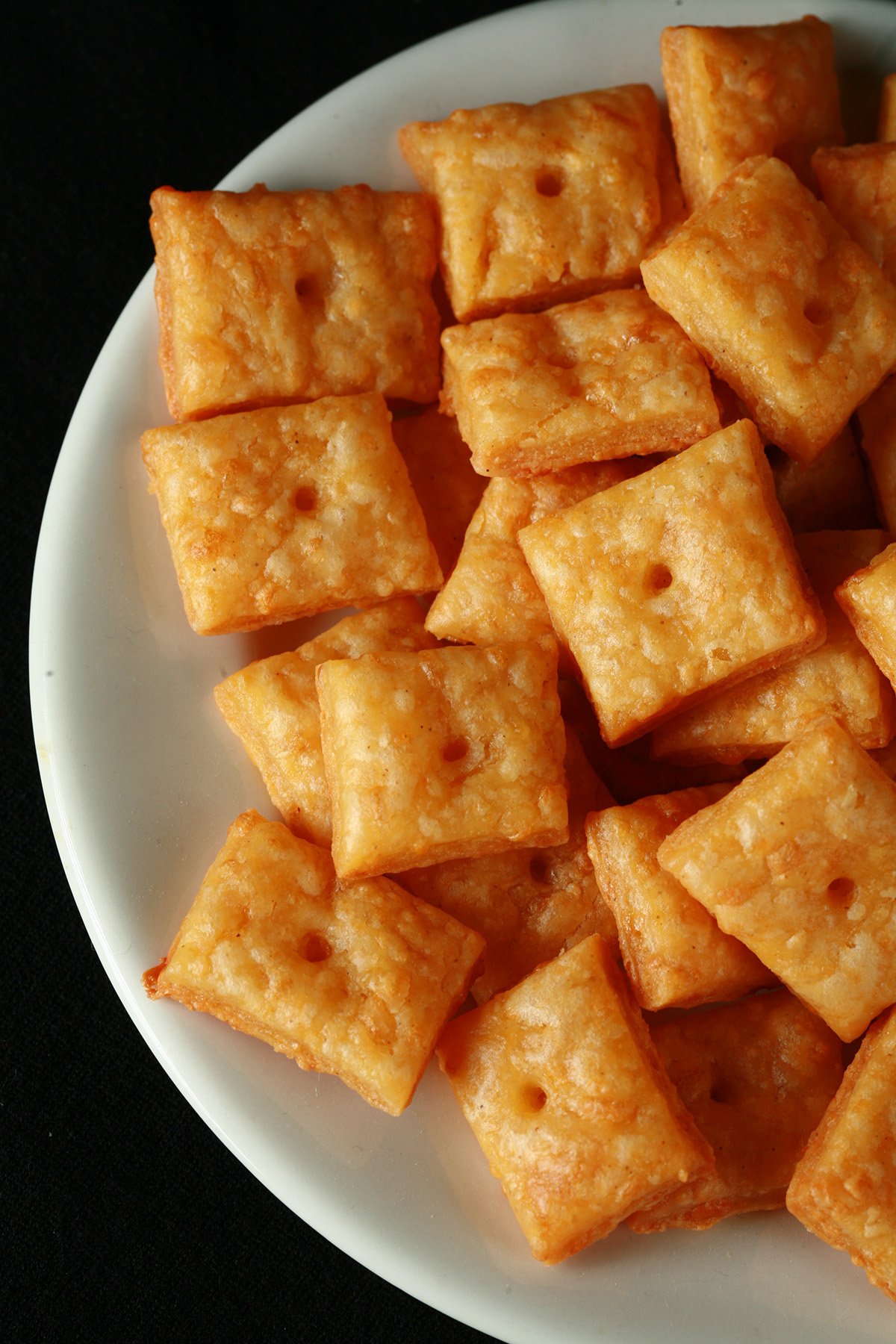 A pile of gluten-Free Cheez-its - little square gluten-free cheese crackers.