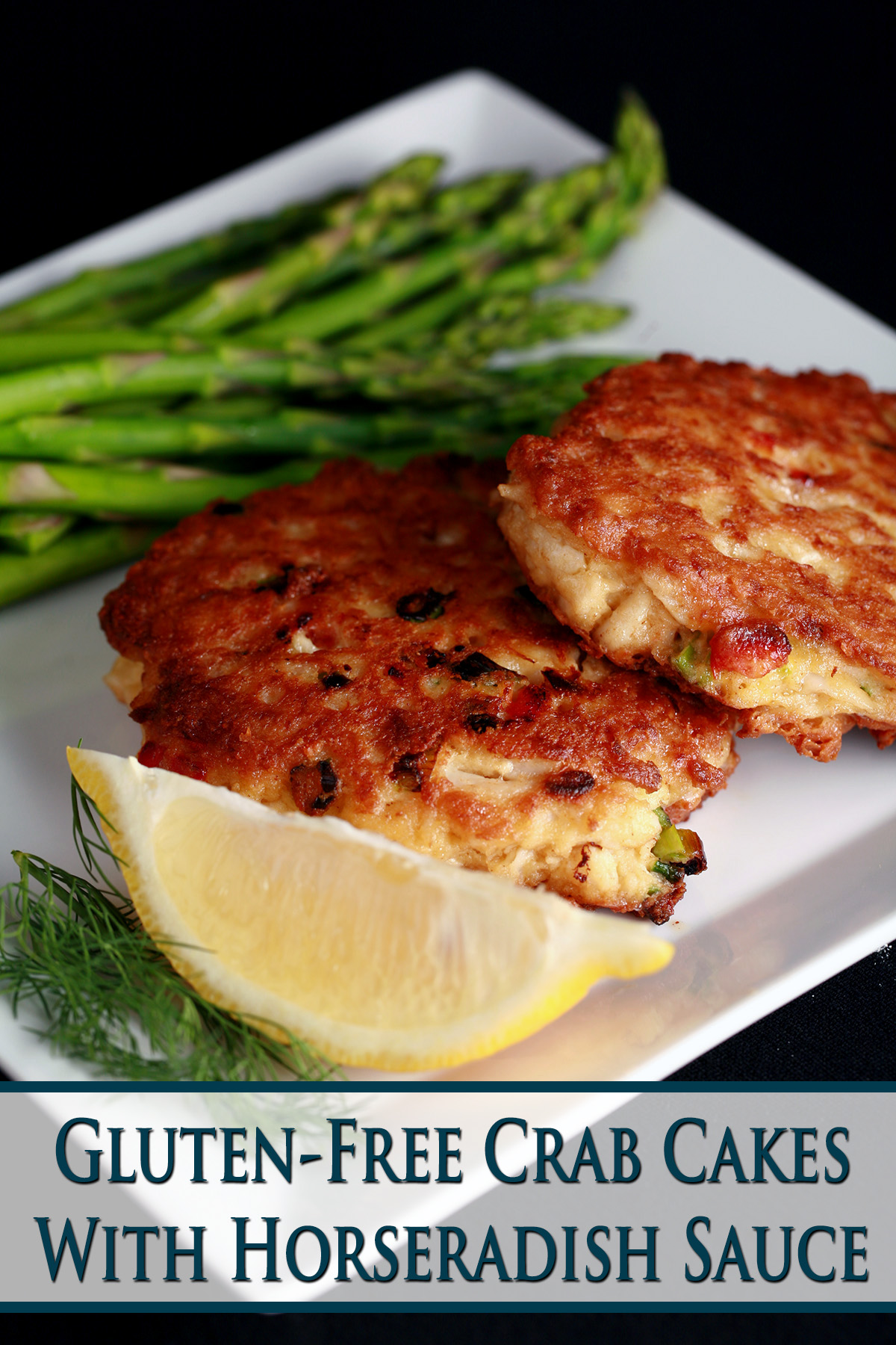 2 Gluten-free Crab Cakes on a plate with asparagus, a lemon slice, and some fresh dill. 