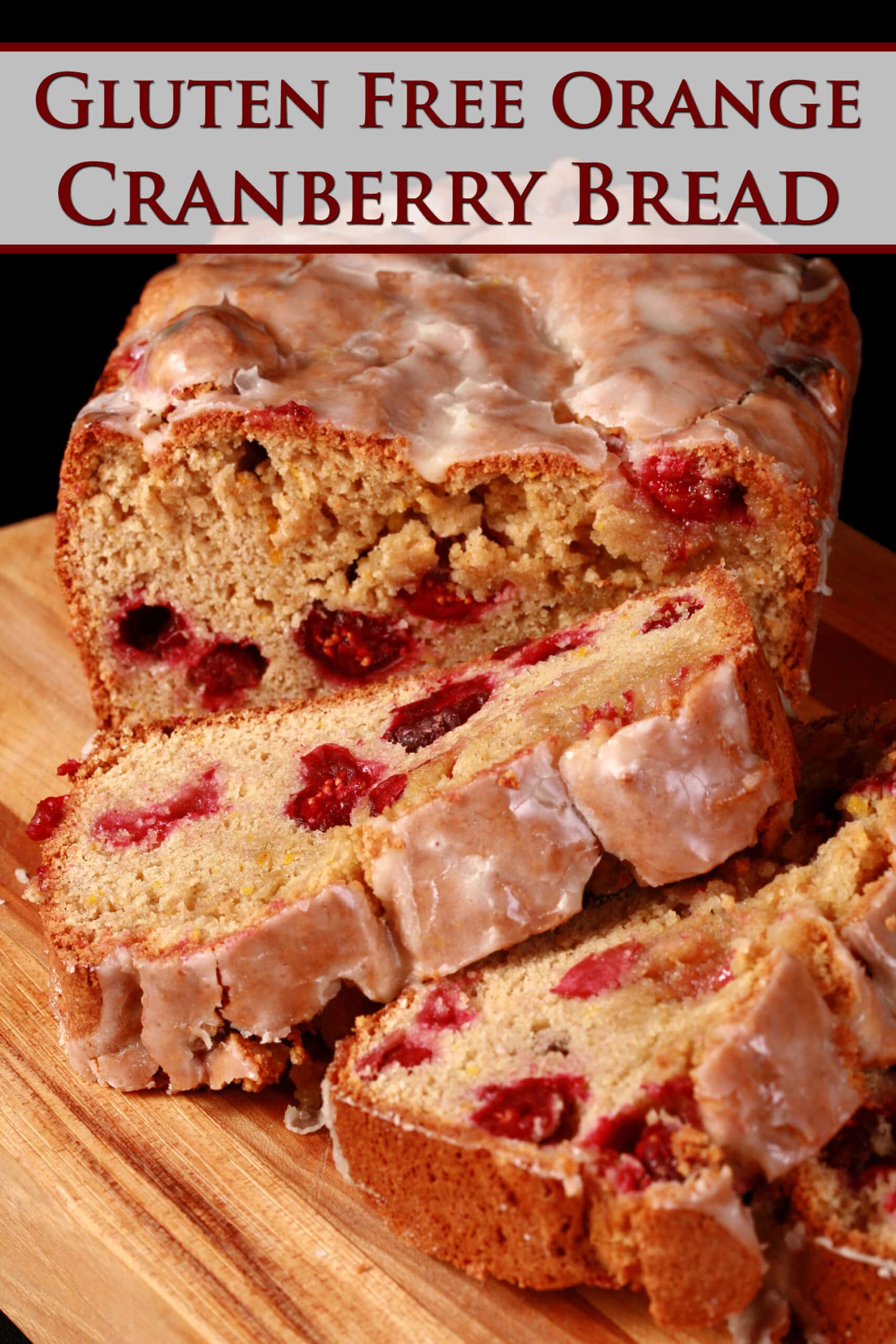 A loaf of glazed gluten free cranberry orange bread, sliced on a cutting board.