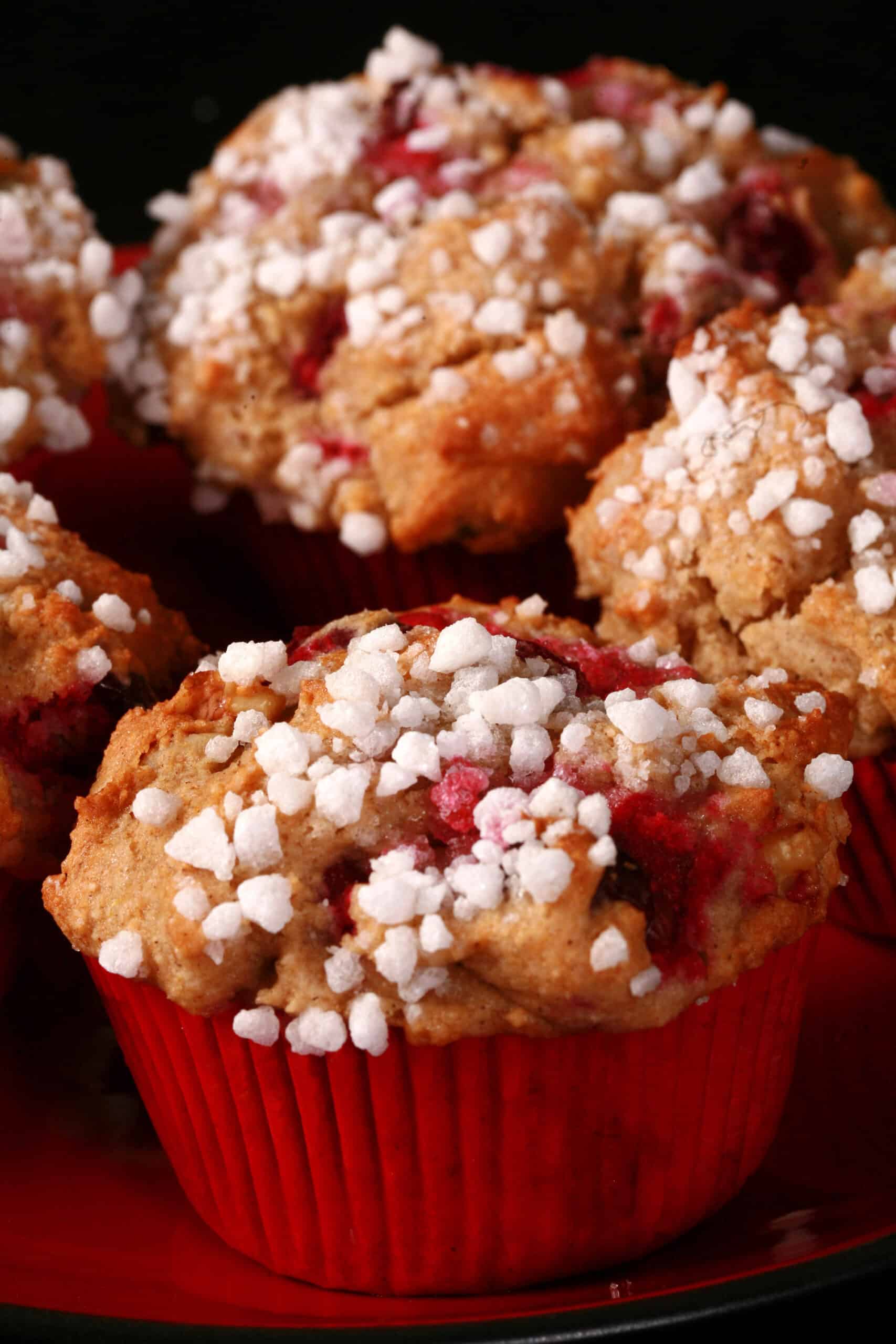 1 plate of gluten-free cranberry muffins with walnuts and a sugar crust on top.