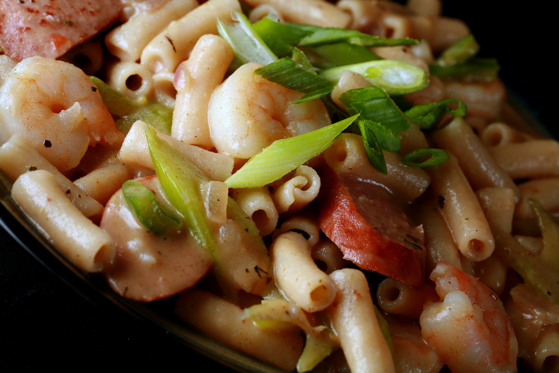 A plate of gluten-Free Creamy Creole Pasta. Shrimp, chicken, sausage, and celery are visible.