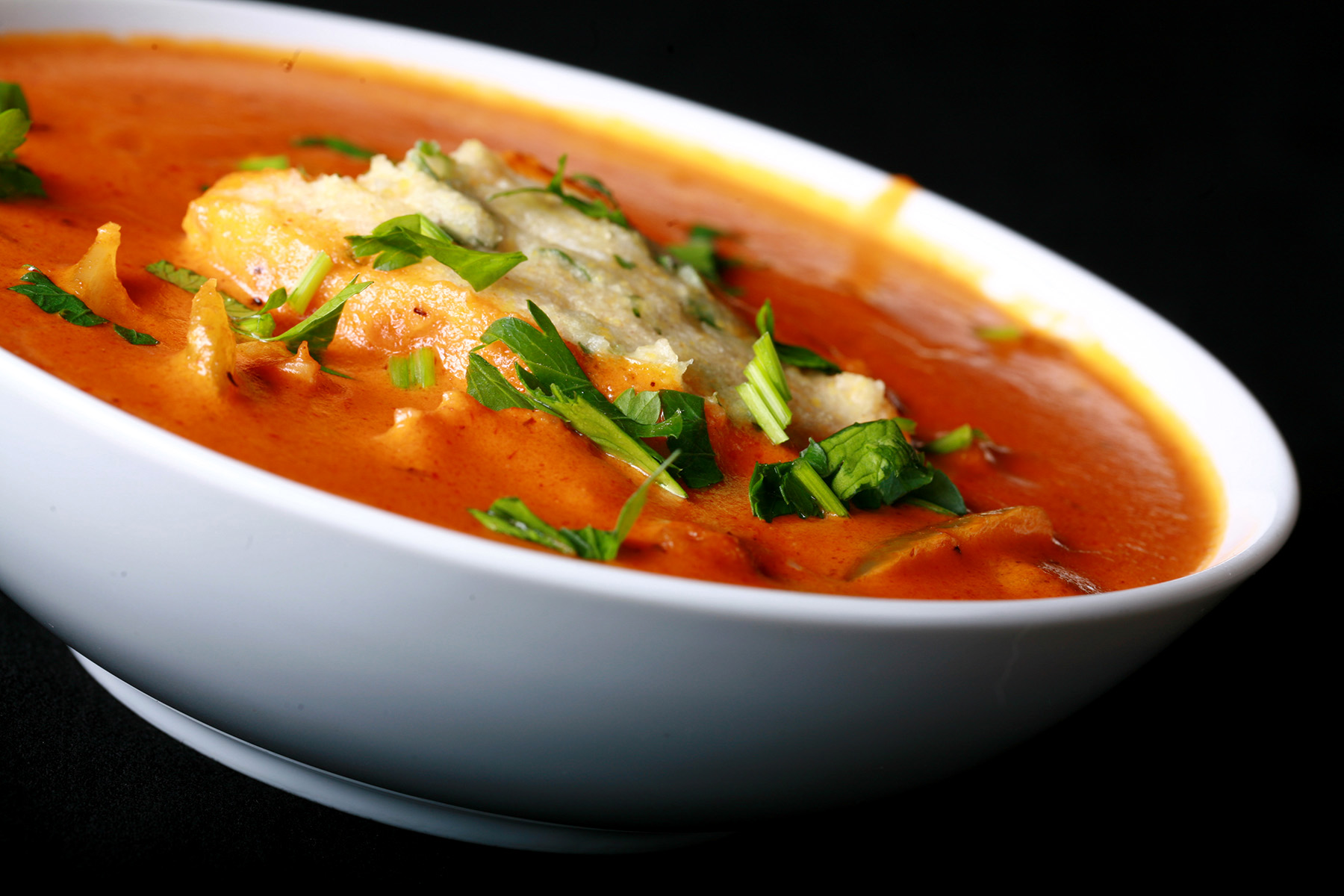 A bowl of gluten-free creamy creole soup with cornmeal dumplings.