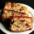 Slices of gluten-free fruitcake, on a small white plate. The cake is generously studded with dried - not candied - fruit.