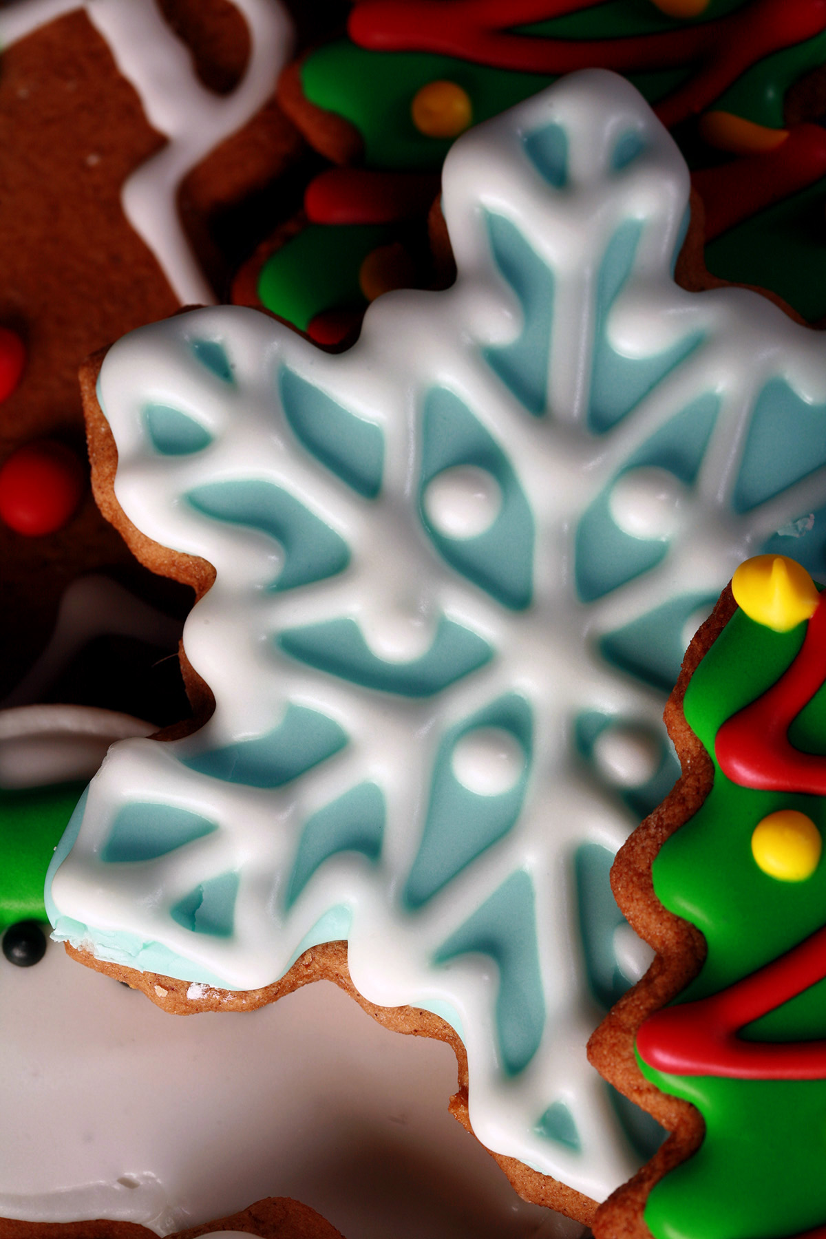 A plate of gluten-free gingerbread cookies, in various shapes, decorated with colourful royal icing.