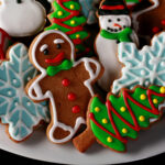 A plate of gluten-free gingerbread cookies, in various shapes, decorated with colourful royal icing.
