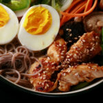 A bowl of gluten free ramen, with chicken and vegetables.