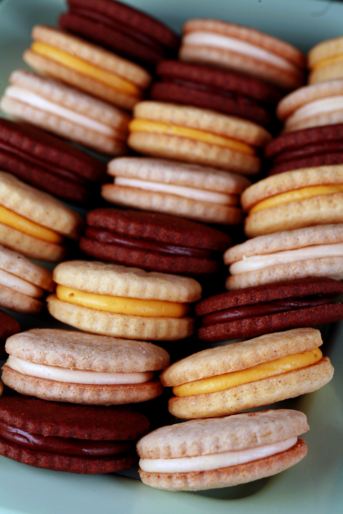 A mixed plate of gluten free sandwich cookies - lemon, chocolate, and vanilla.