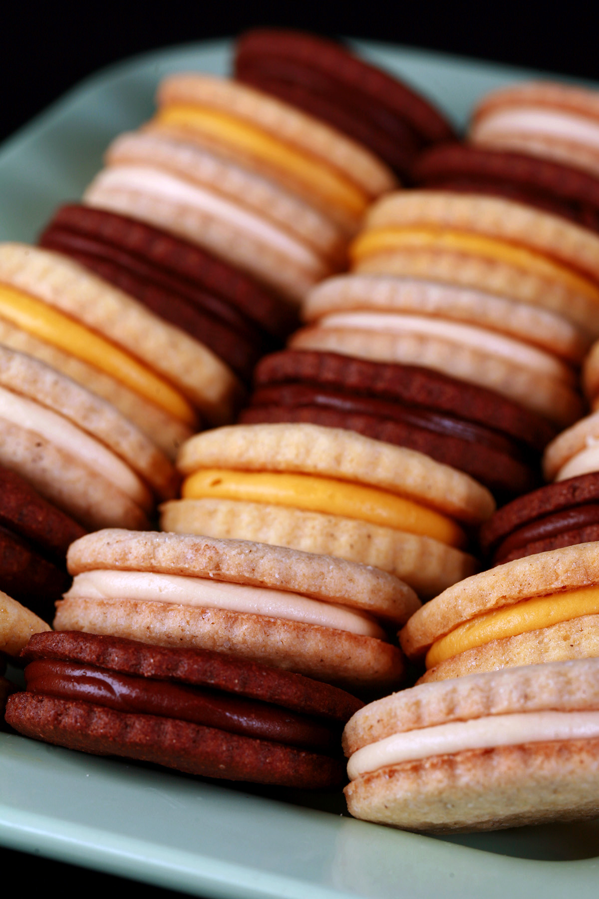 A mixed plate of gluten free sandwich cookies - lemon, chocolate, and vanilla.