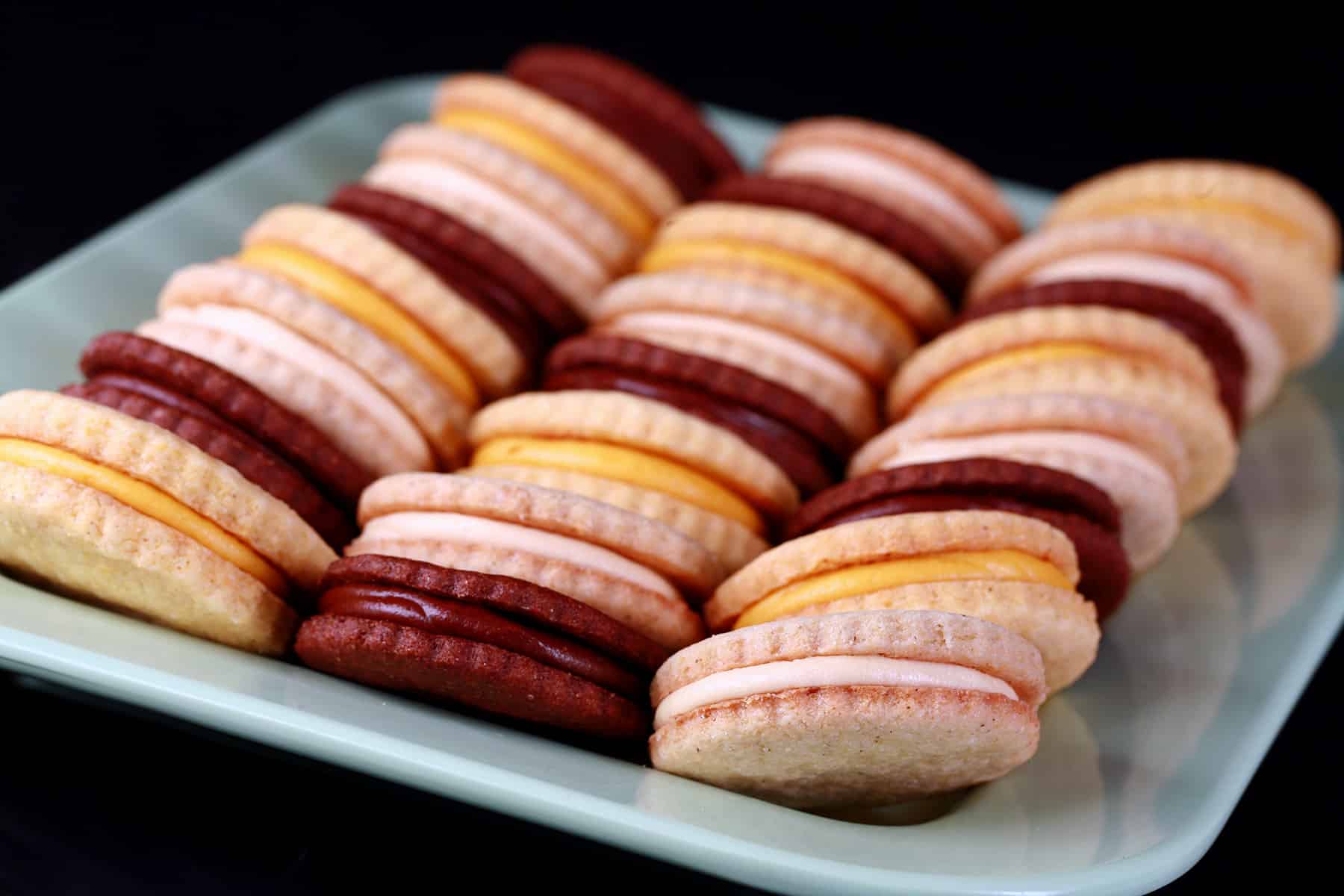 A mixed plate of gluten free sandwich cookies - lemon, chocolate, and vanilla.
