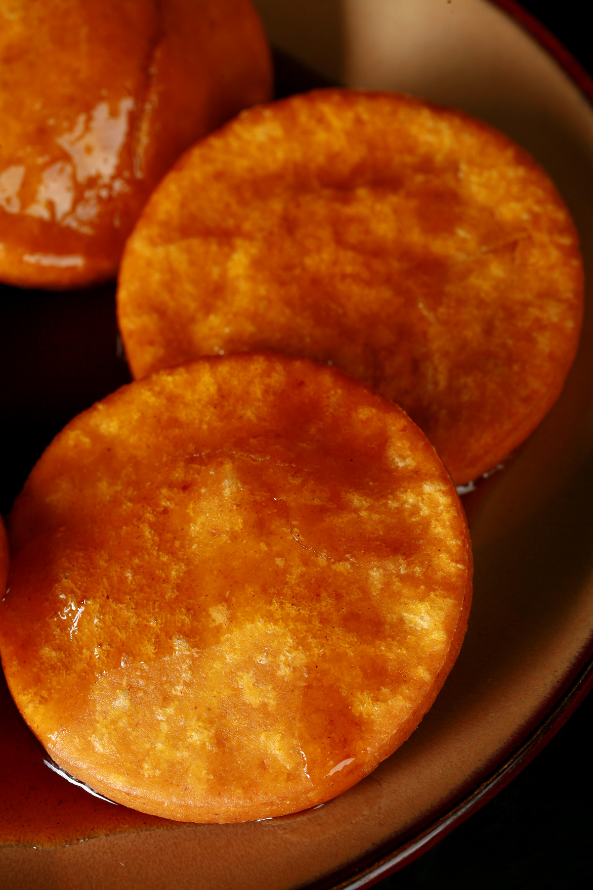 A plate of gluten free sopaipilla pasadas, with sauce drizzled over them.