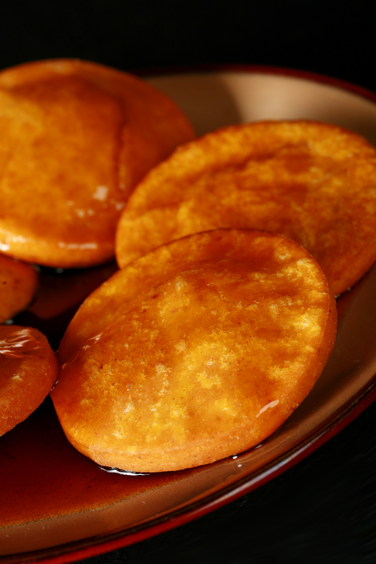A plate of gluten free sopaipilla pasadas, with sauce drizzled over them.