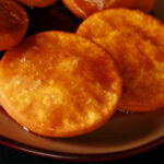 A plate of gluten free sopaipilla pasadas, with sauce drizzled over them.