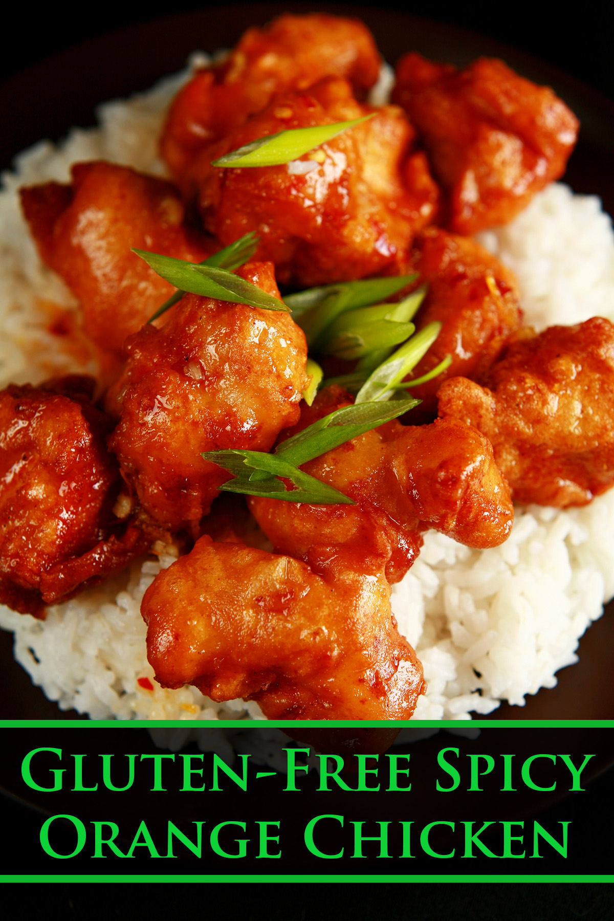 A plate of rice, covered with gluten-free orange chicken: Chunks of battered and deep fried chicken coated in a glossy orange sauce, garnished with sliced green onions.