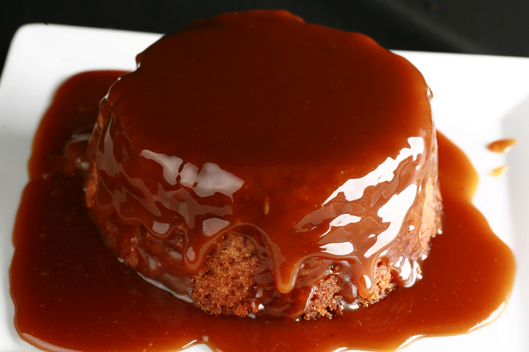 A gluten free sticky toffee pudding with whiskey toffee sauce over it.