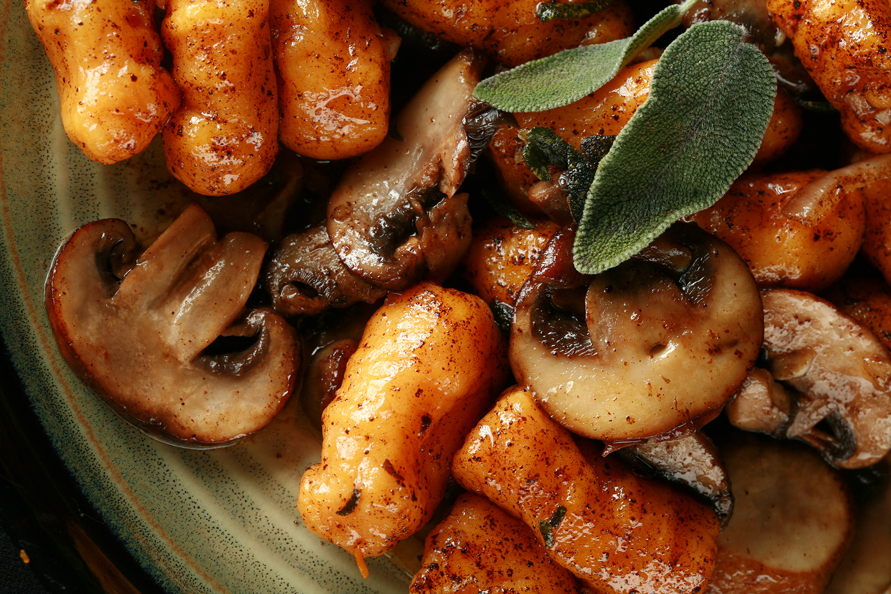 Close up view of AIP sweet potato gnocchi with mushrooms and sage.
