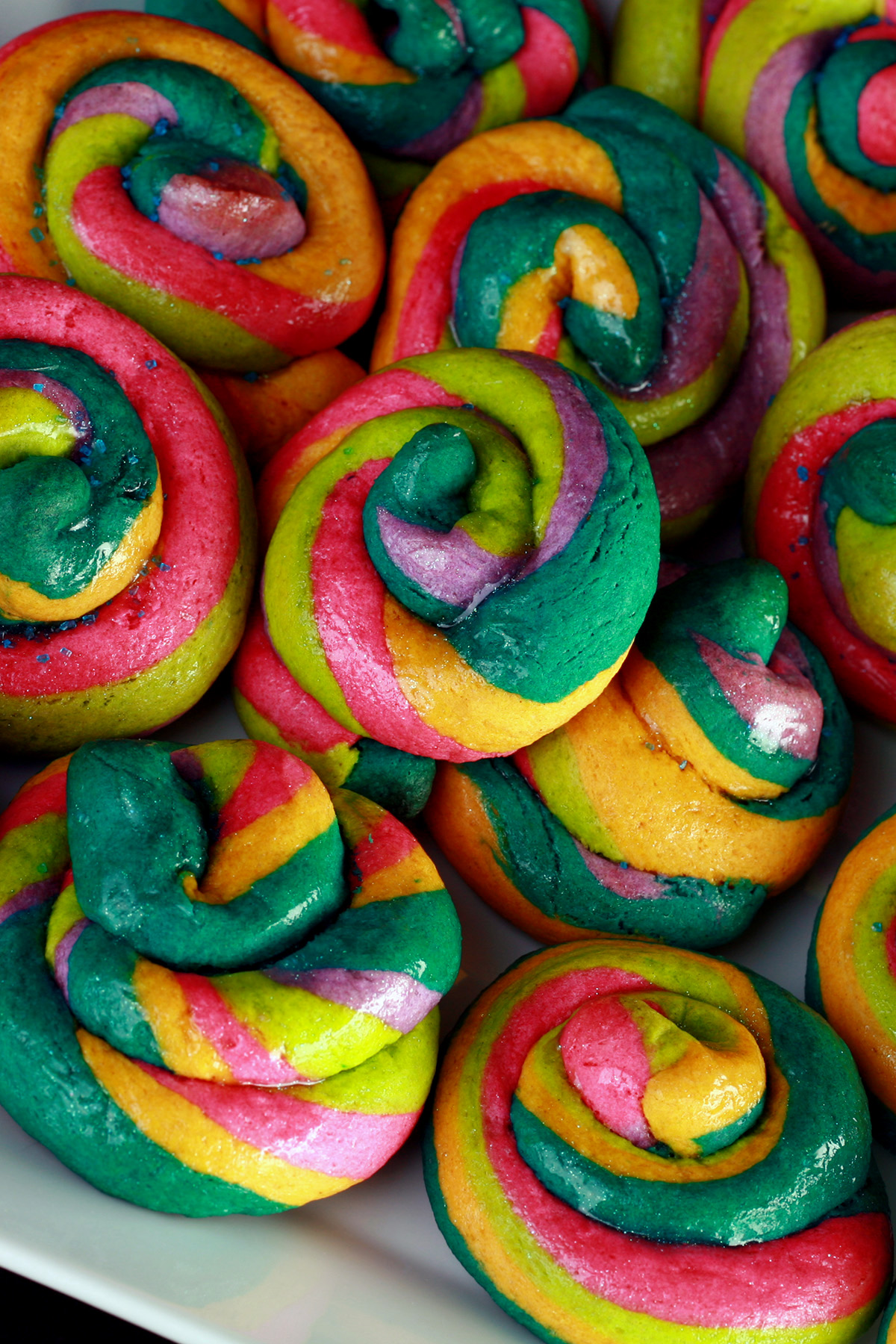 A close up view of a pile of gluten-free unicorn poop cookies. They are brightly coloured cookie "poops" made from brightly coloured twists of cookie dough.