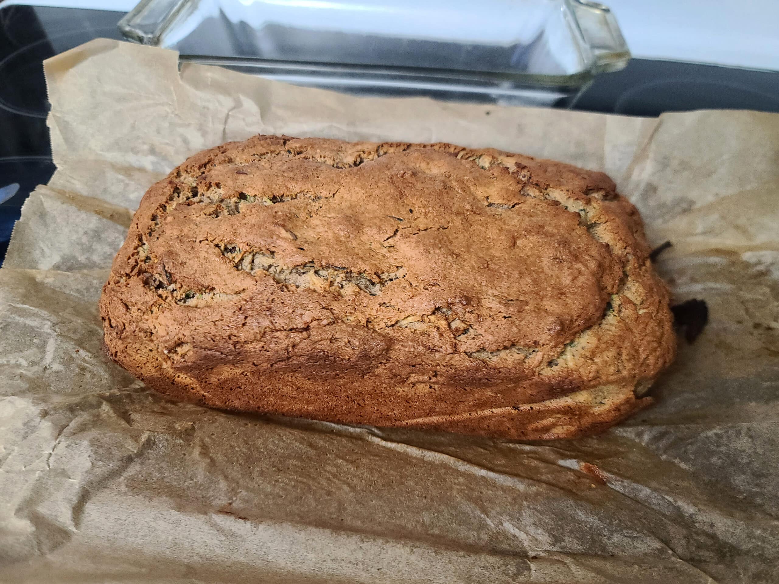 The baked gluten-free zucchini loaf, sitting on the parchment paper it was baked in.