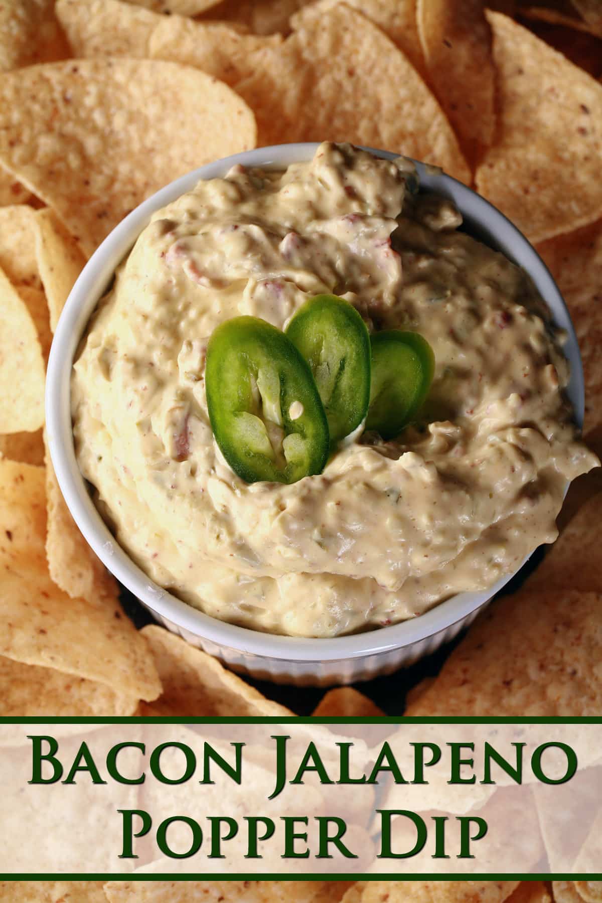 A ramekin of gluten free jalapeno dip, surrounded by corn chips and topped with sliced jalapenos.