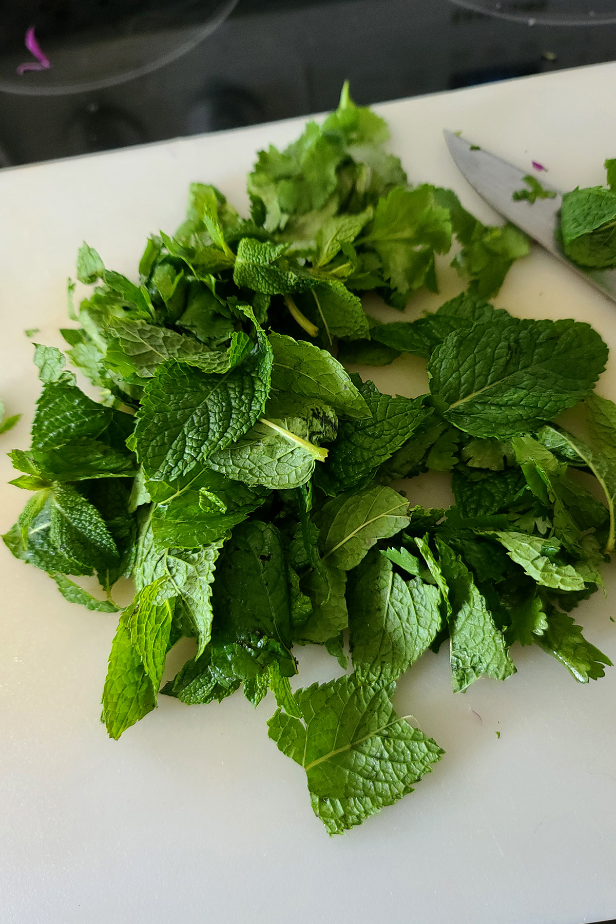 Cilantro and mint on a cutting board.